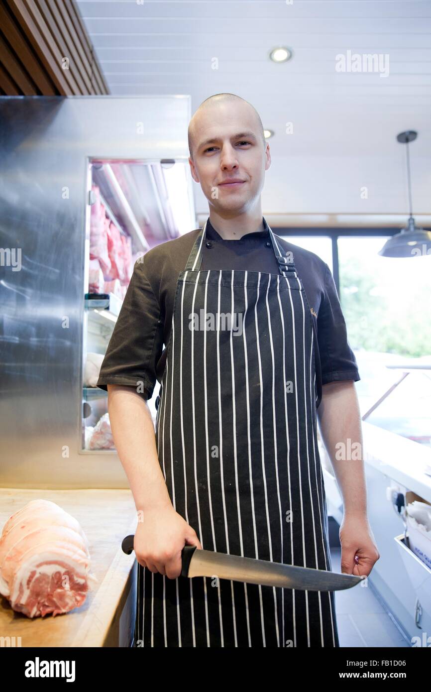 Portrait de butcher holding couteau en bouchers bouchers shop Banque D'Images