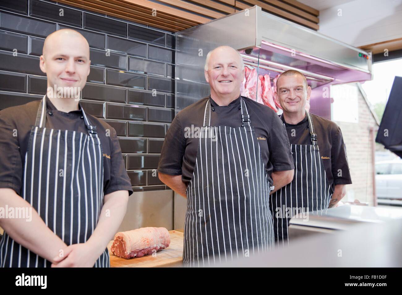 Portrait de trois bouchers masculins dans les boucheries shop Banque D'Images