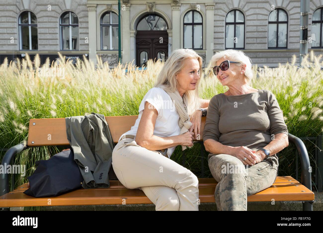 La mère et la fille assis sur un banc à l'extérieur, ensemble Banque D'Images