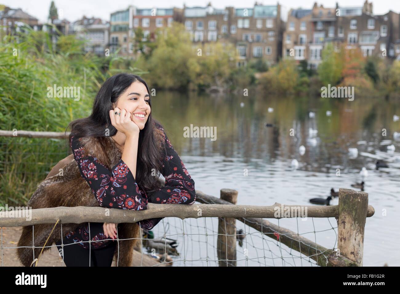 Young woman relaxing by lake, Hampstead Heath, Londres Banque D'Images