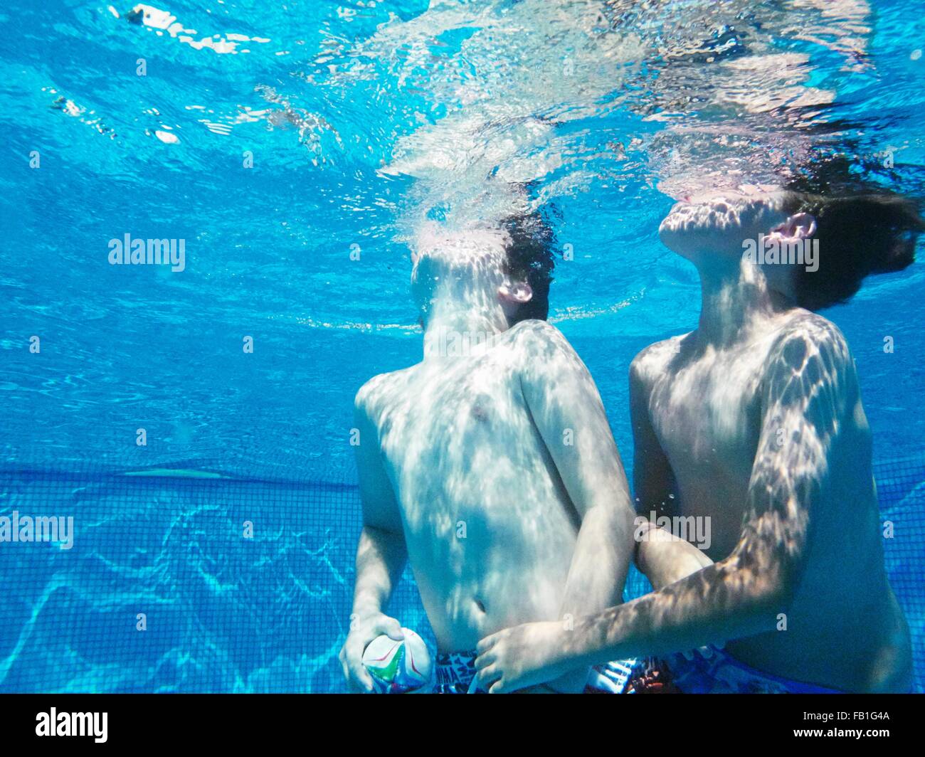 Sous-vue de deux garçons jouer au ballon en jeu piscine Banque D'Images