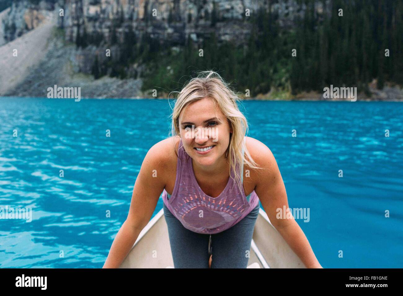 Portrait of mid adult woman en canoë sur le lac Moraine, smiling at camera, Banff National Park, Alberta Canada Banque D'Images