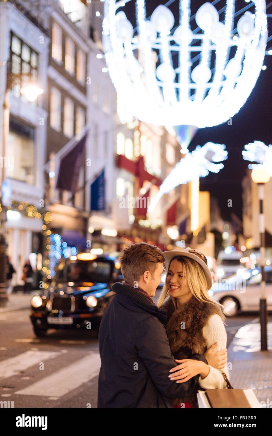 Jeune couple romantique sur New Bond Street à Noël, à Londres, Royaume-Uni Banque D'Images