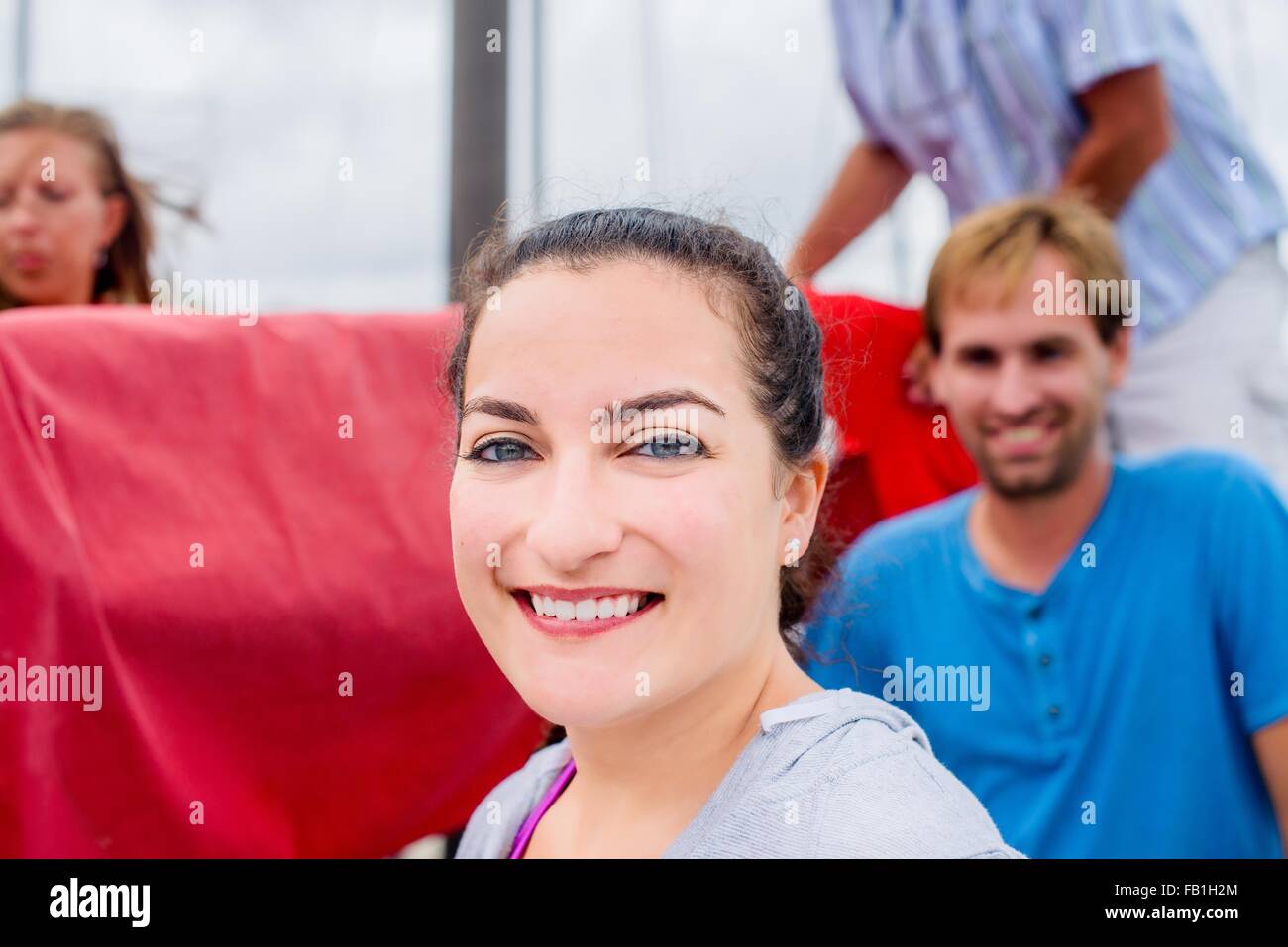 Portrait de jeune femme, les cheveux attachés en arrière à la caméra en souriant Banque D'Images