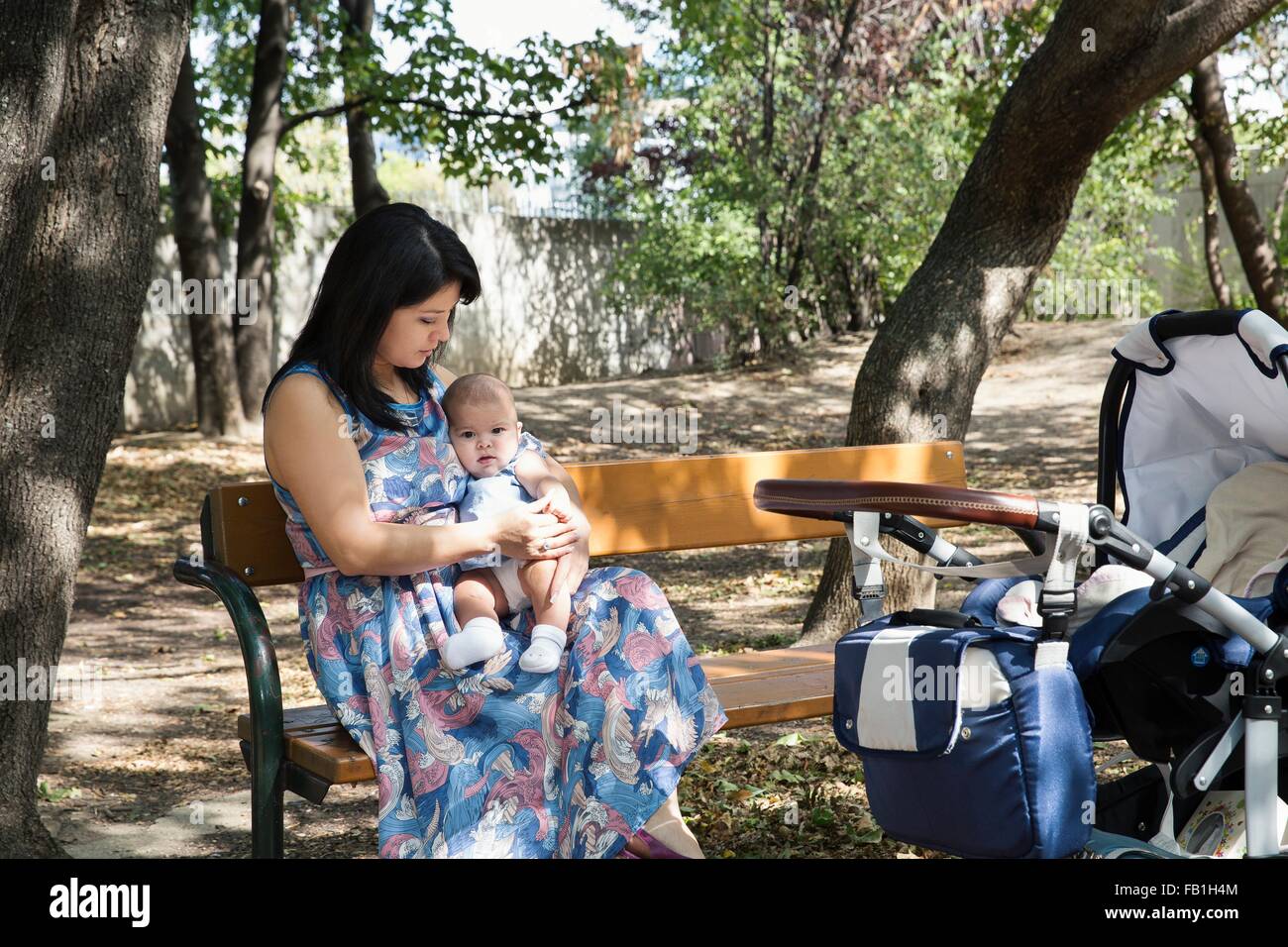 Grand-mère assise sur banc de parc avec bébé fille Banque D'Images