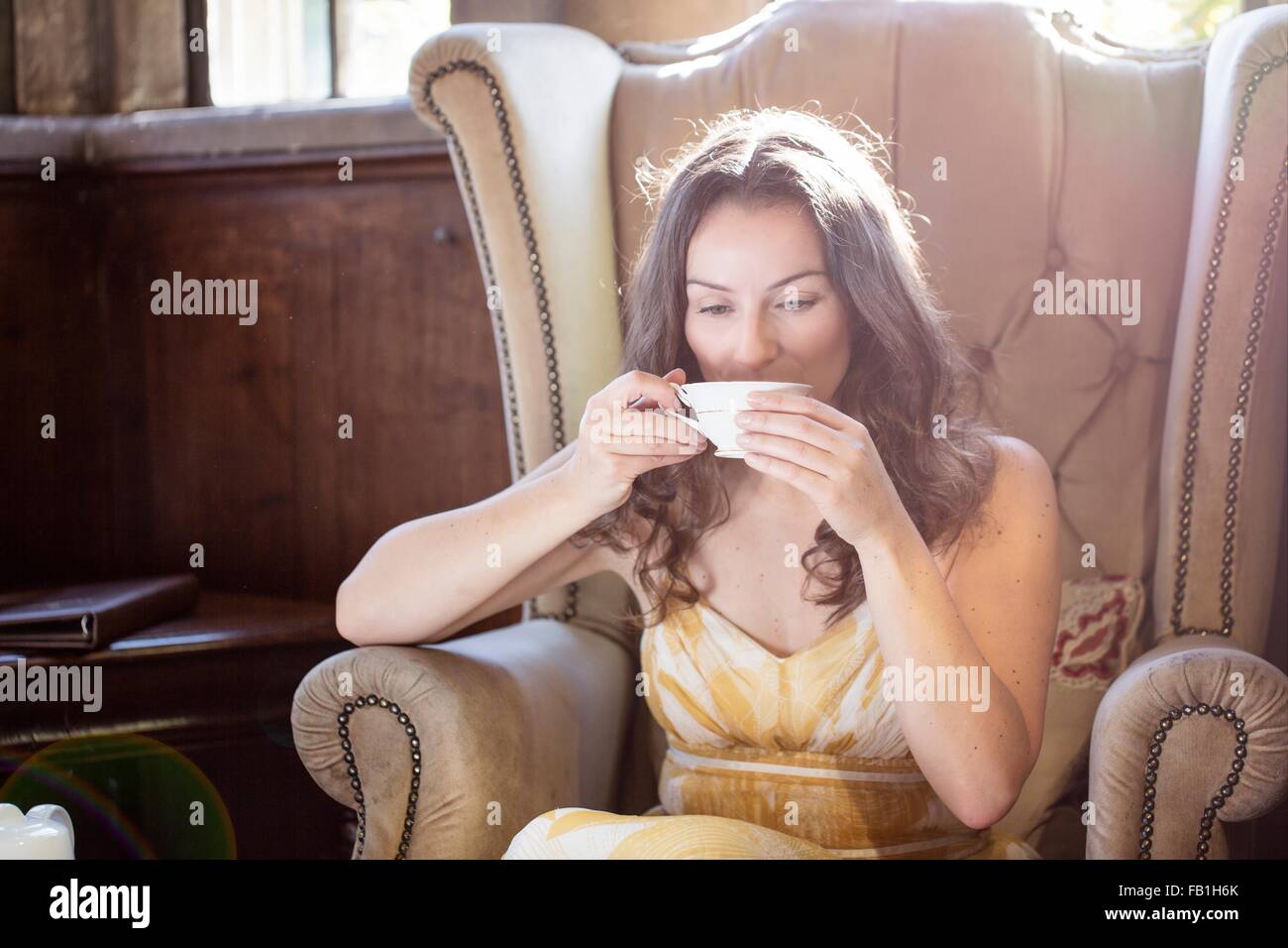 Femme buvant une tasse de thé dans la région de vieux fauteuil au Château de Thornbury, South Gloucestershire, Royaume-Uni Banque D'Images