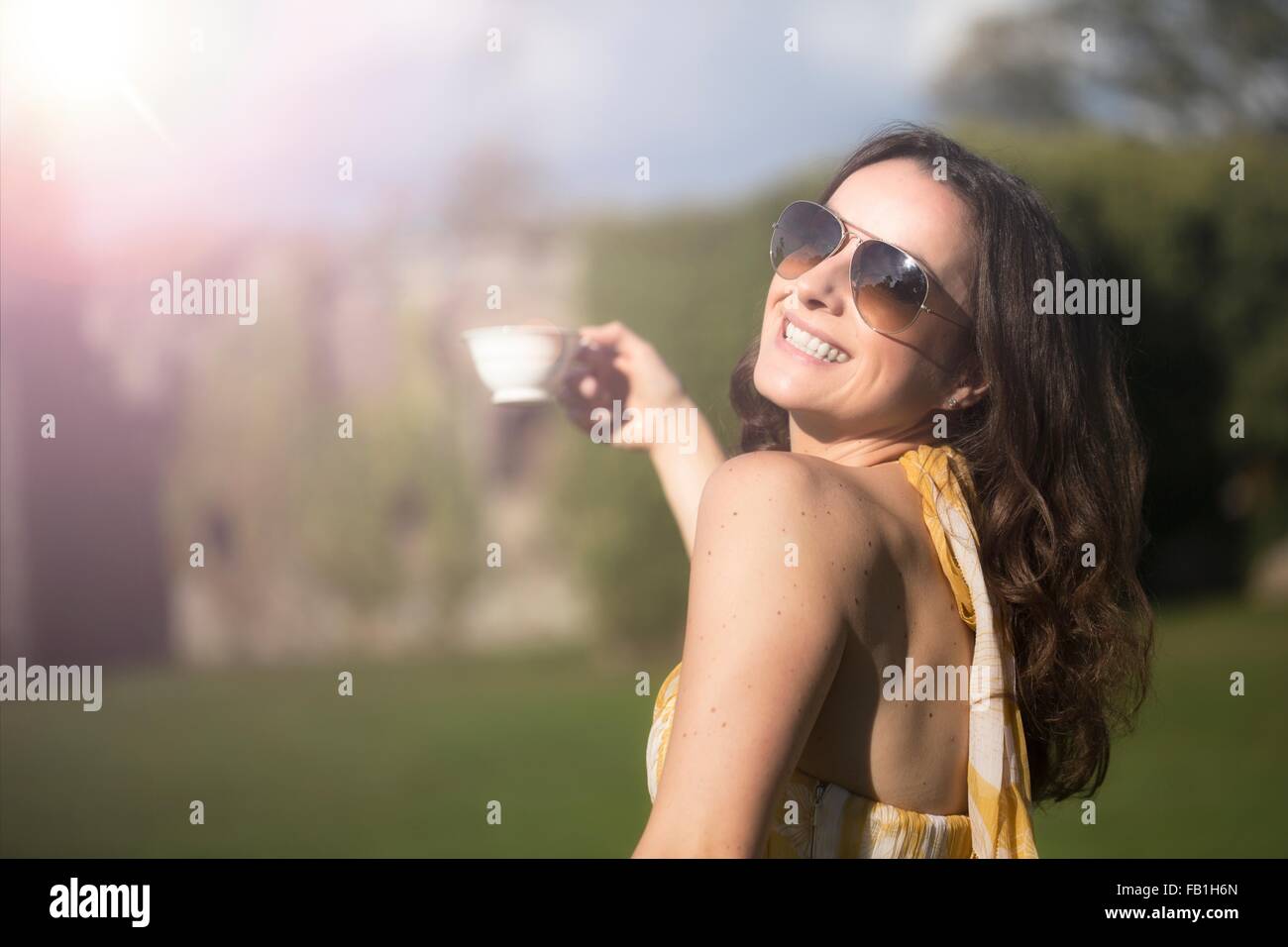 Femme regardant par-dessus son épaule posant avec tasse de thé au Château de Thornbury, South Gloucestershire, Royaume-Uni Banque D'Images Femme regardant par-dessus son épaule posant avec tasse de thé au Château de Thornbury, South Gloucestershire, Royaume-Uni Banque D'Images
