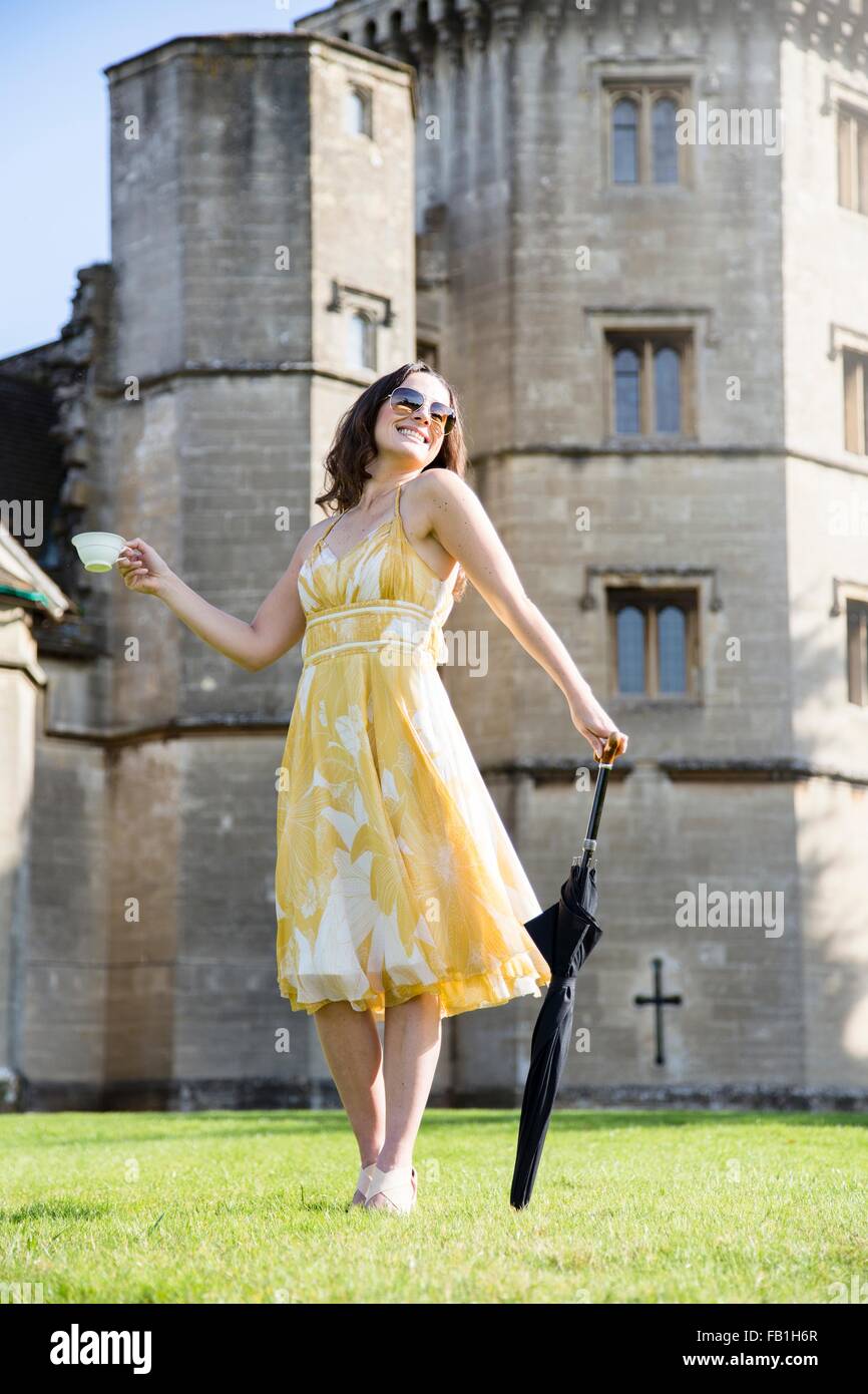 Femme posant avec tasse de thé et parapluie à Thornbury Castle, South Gloucestershire, Royaume-Uni Banque D'Images Femme posant avec tasse de thé et parapluie à Thornbury Castle, South Gloucestershire, Royaume-Uni Banque D'Images