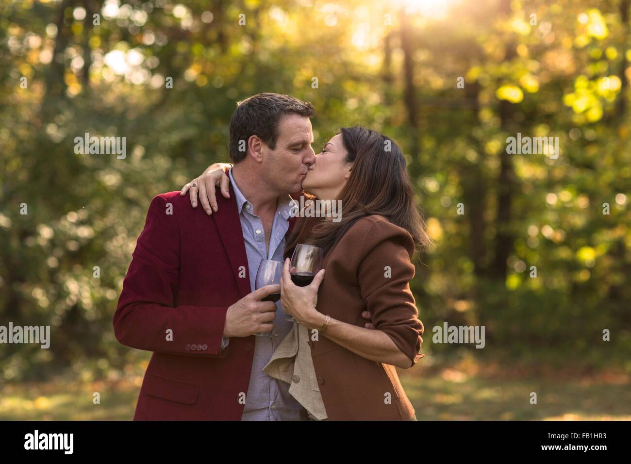 Close up of mature couple kissing in garden Banque D'Images