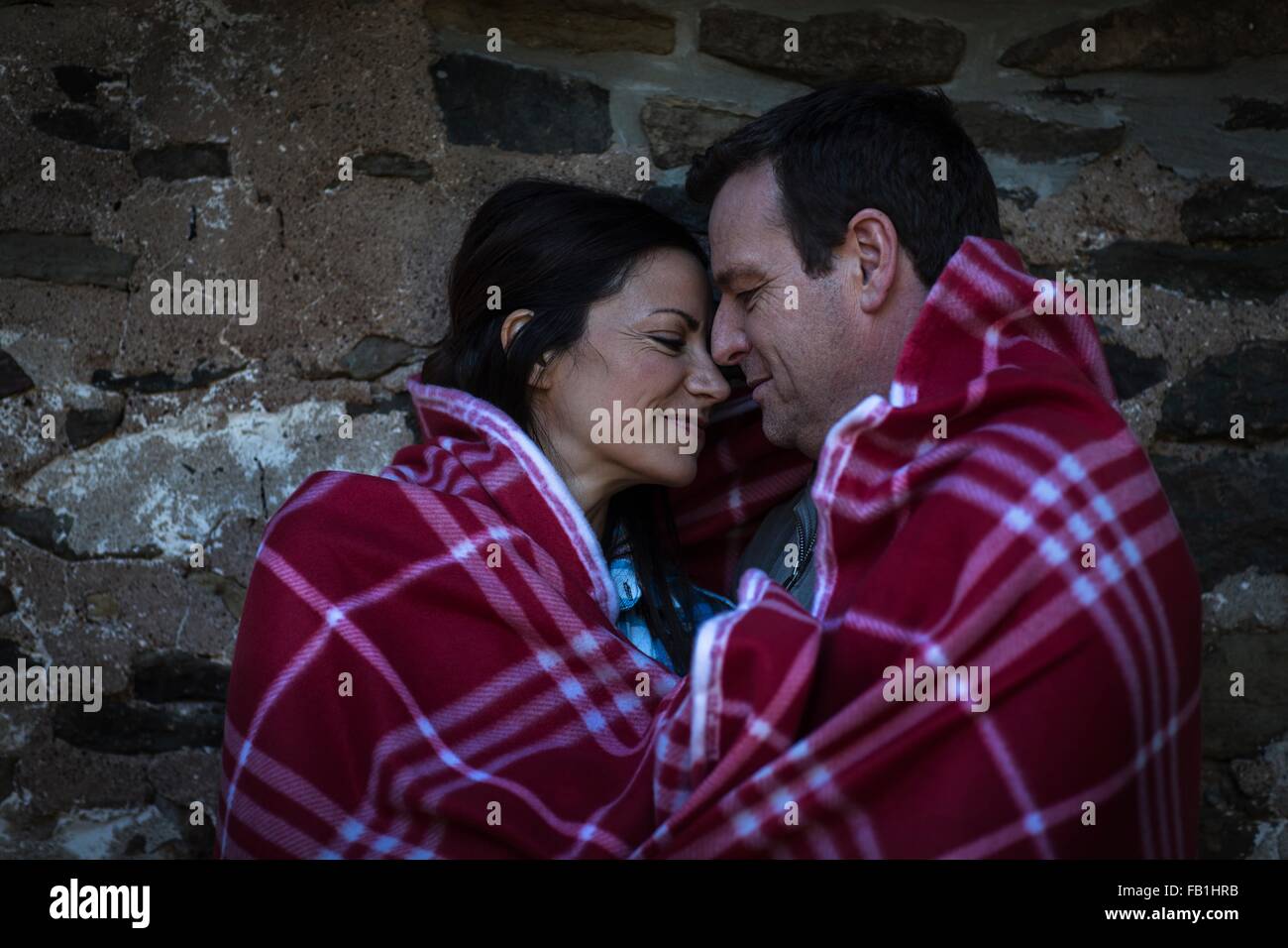 Couple romantique tête à tête enveloppée dans une couverture de nuit Banque D'Images