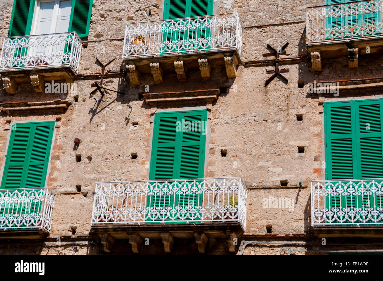 Vieille maison en pierre italienne avec obturateur vert avant les stores et balcon à Tropea Banque D'Images