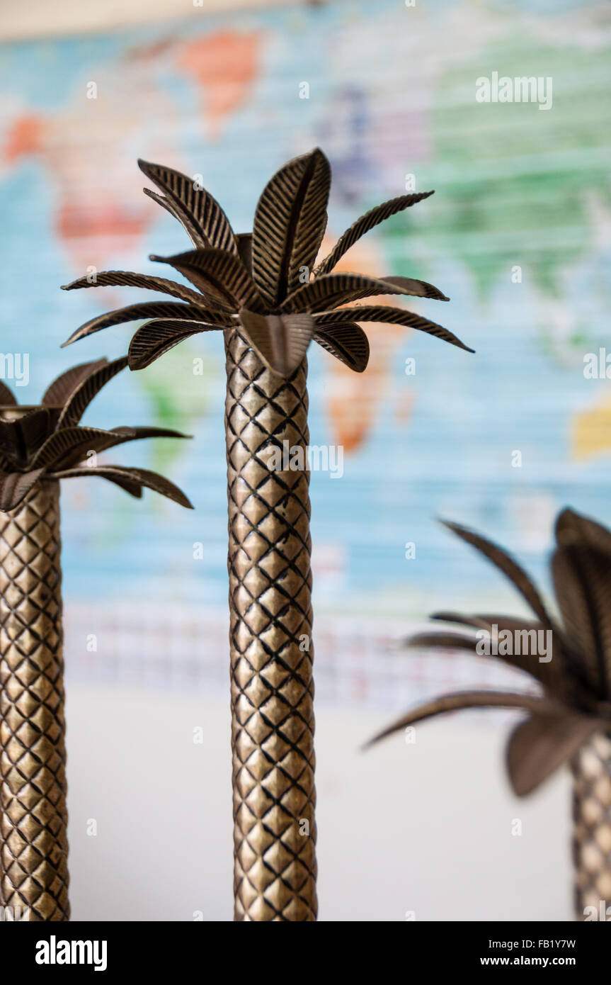 Petit palmier décoration métallique en face de la carte du monde Banque D'Images