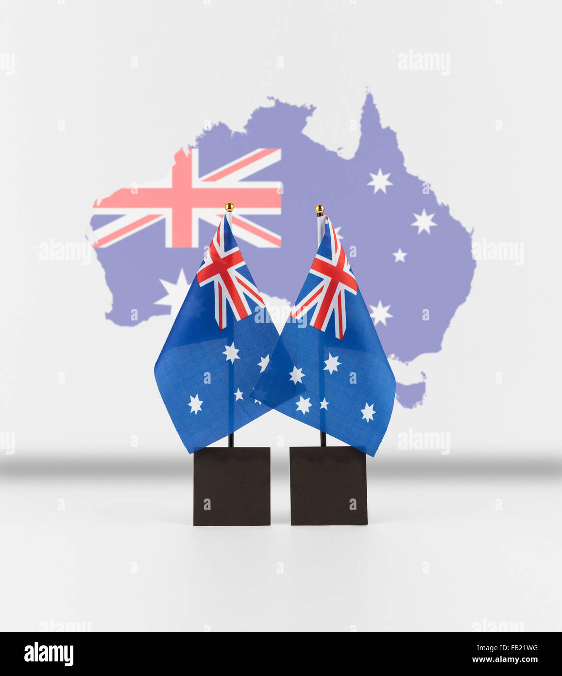 Deux drapeaux australiens 24 avec carte de l'Australie dans l'arrière-plan et l'espace de copie. Symboles nationaux australien isolé sur blanc. Banque D'Images