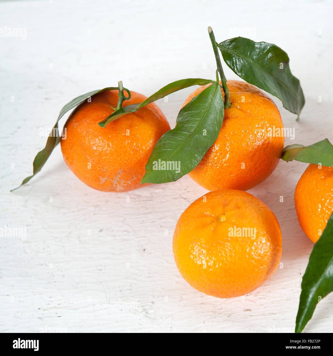 La mandarine douce sur table en bois en face du mur blanc. Banque D'Images