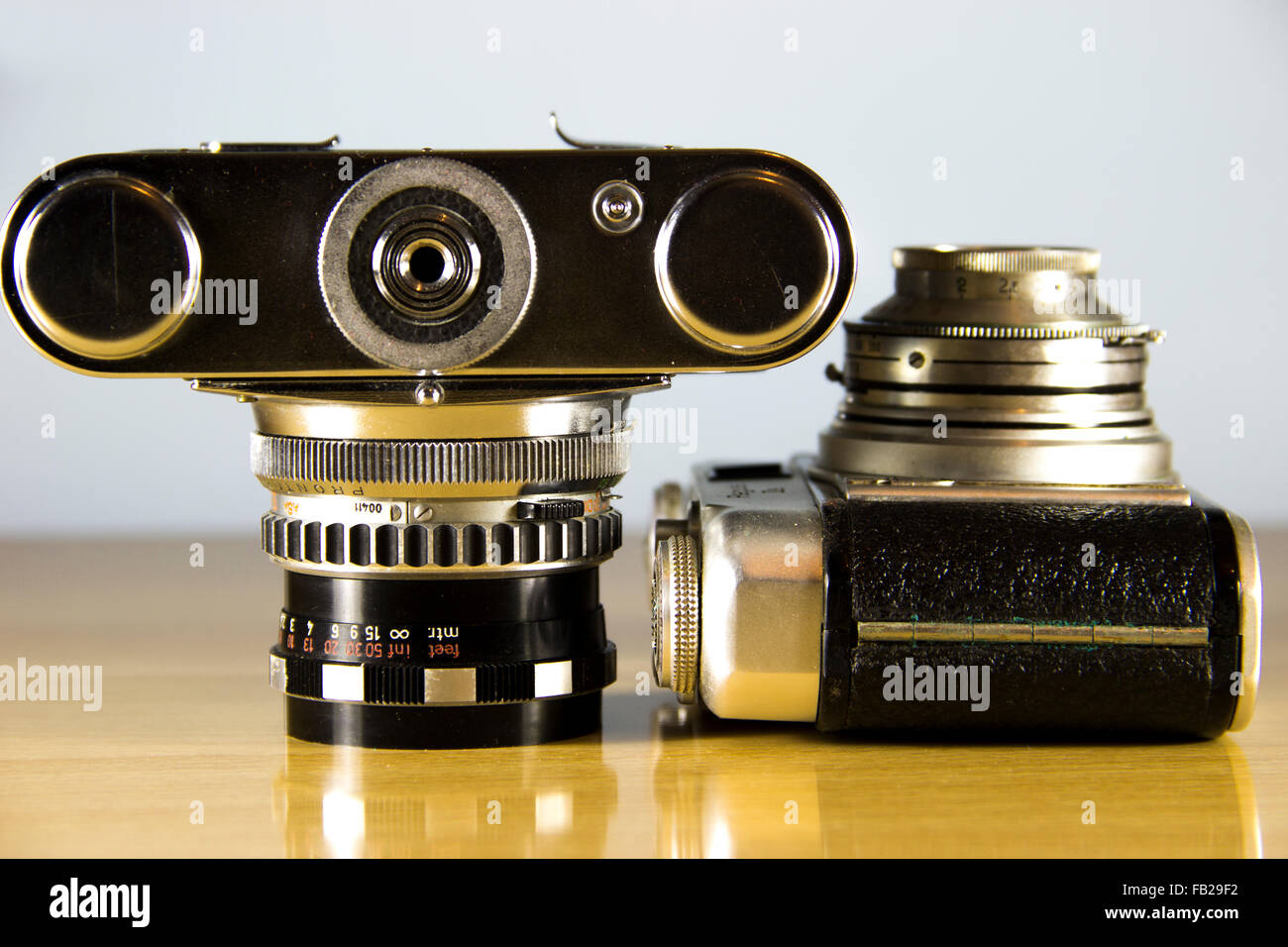 Deux anciennes caméras 35mm analogique présentée sur une table en bois Banque D'Images