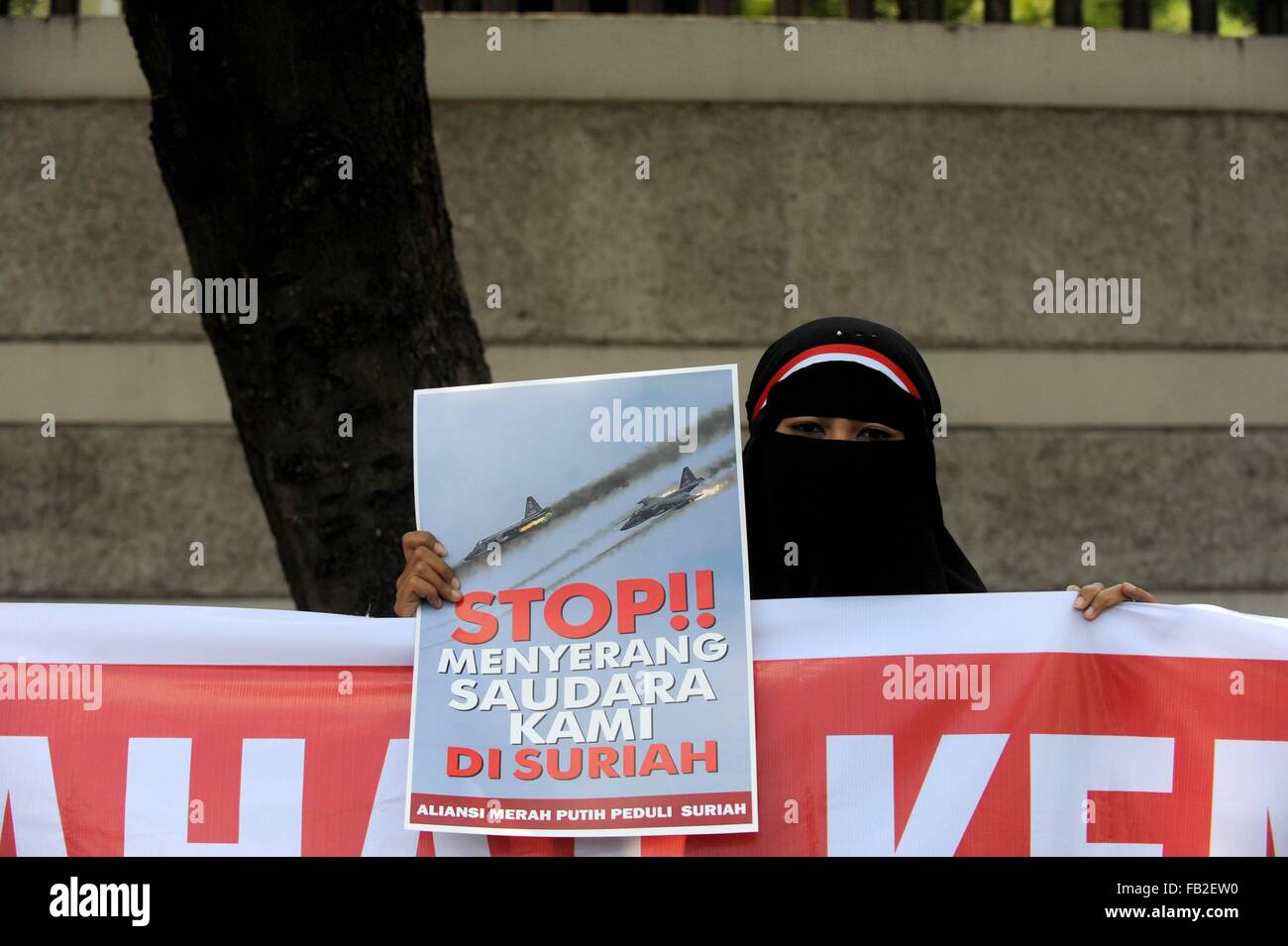 Jakarta, Indonésie. 8 janvier, 2016. Une femme musulmane indonésienne est titulaire d'un placard pendant un rassemblement contre les frappes aériennes lancées par la Russie en Syrie à l'ambassade de Russie à Jakarta, Indonésie, le 8 janvier 2016. Ti'Kuncahya Crédit : B./Xinhua/Alamy Live News Banque D'Images