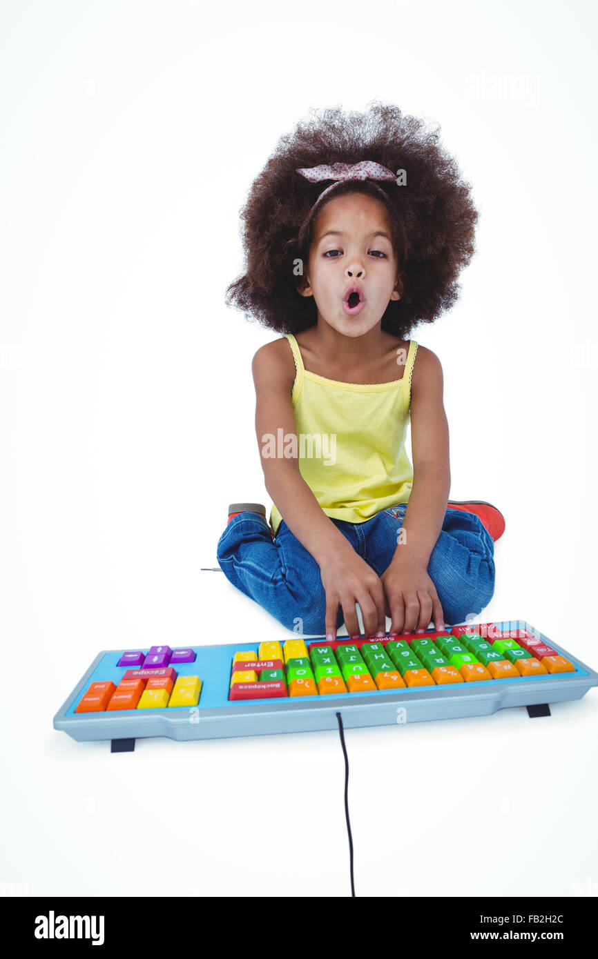 Jolie fille assise sur le sol à l'aide clavier couleur Banque D'Images