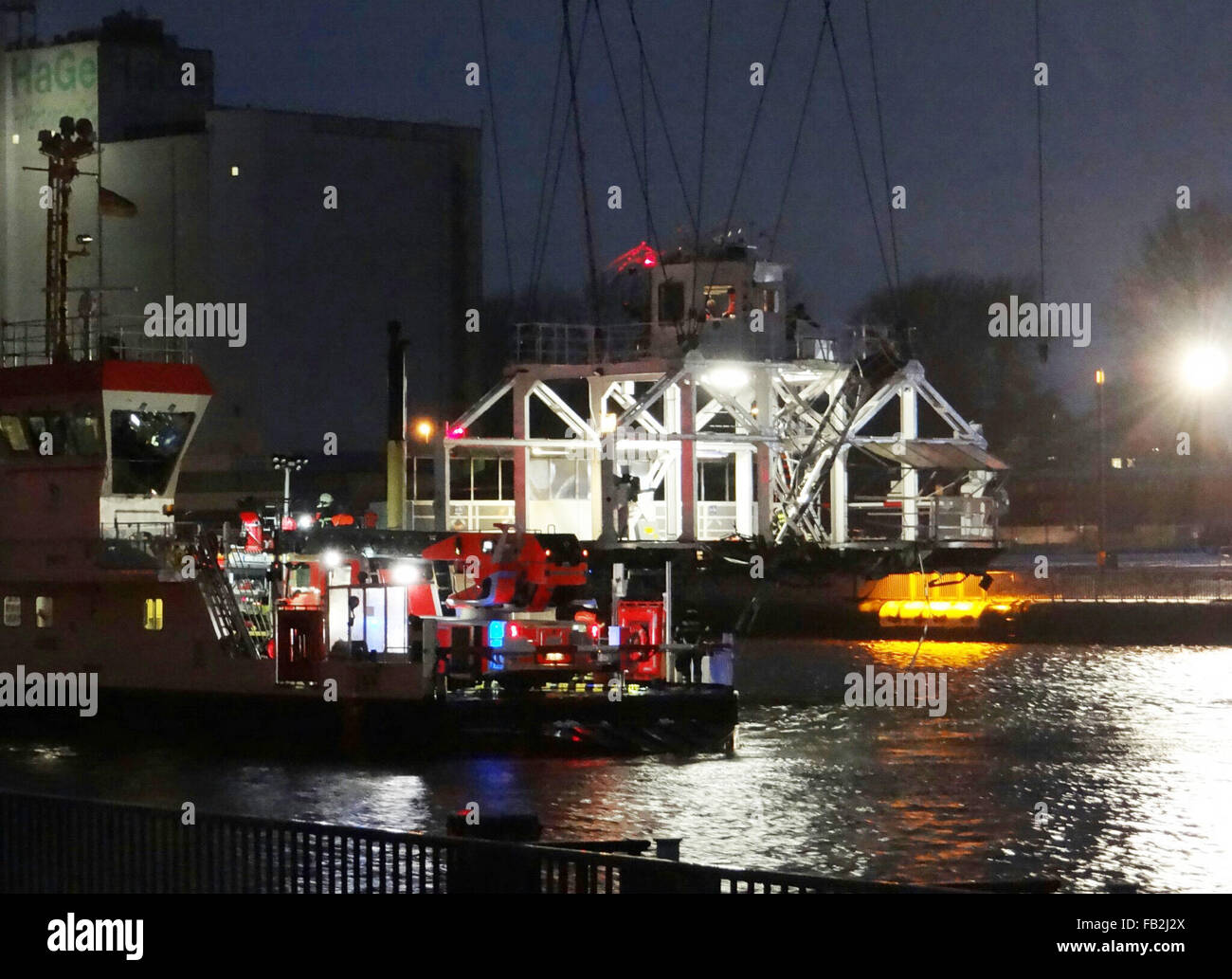 Rendsburg, Allemagne. 8 janvier, 2015. Les travailleurs d'urgence des pompiers sécuriser un pont transbordeur endommagés (L) qui se joint à câbles en acier suspendu au-dessus du canal de Kiel, Allemagne, près de Rendsburg 8 janvier 2015. Un navire de charge étaient entrés en collision avec le pont transbordeur avec deux personnes blessées. La cause de l'accident restait incertaine. PHOTO : CARSTEN REHDER/dpa/Alamy Live News Banque D'Images