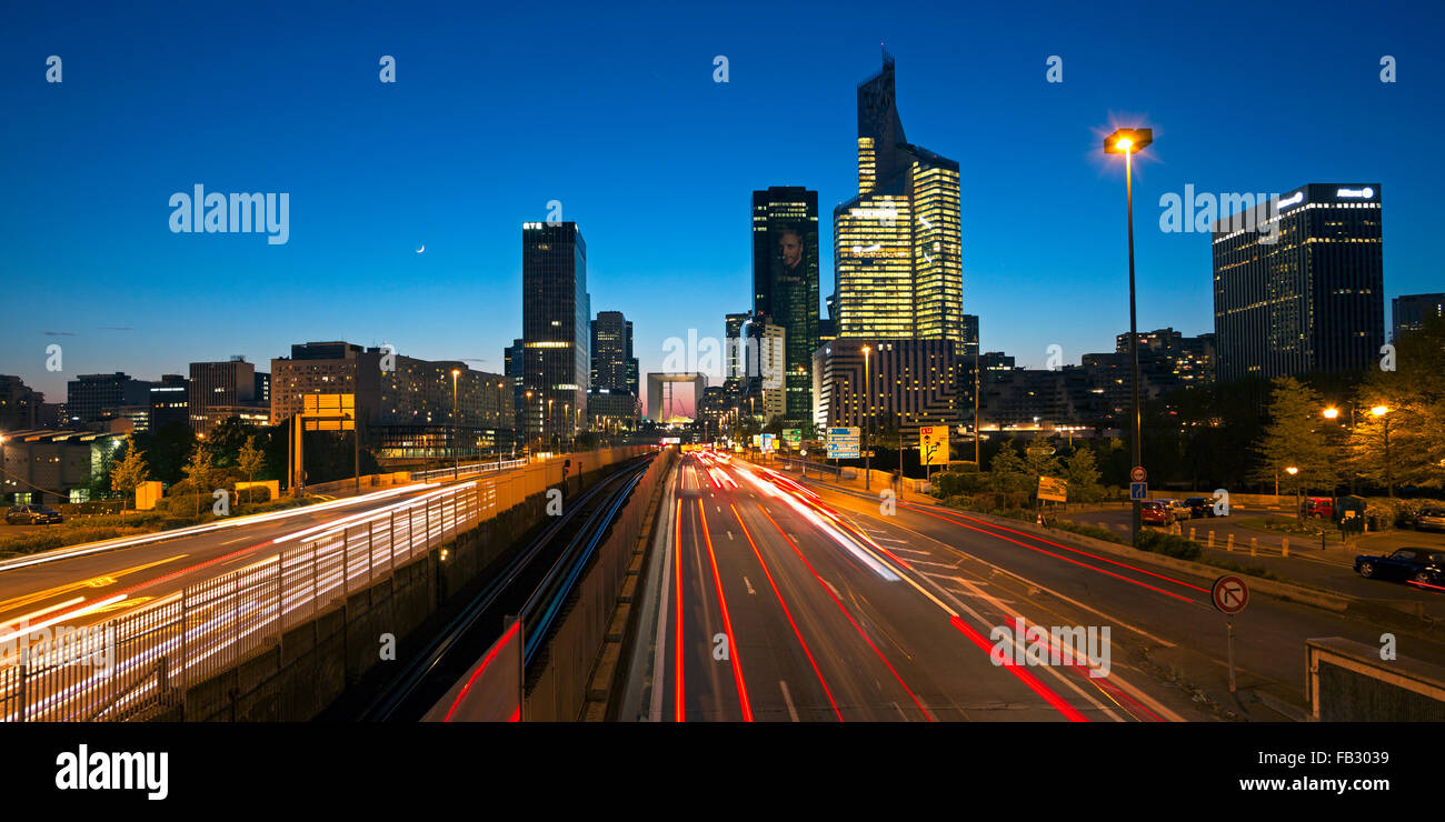 Route de Paris la nuit menant vers la Grande Arche et immeubles de bureaux modernes à la Defense, Paris, France Banque D'Images