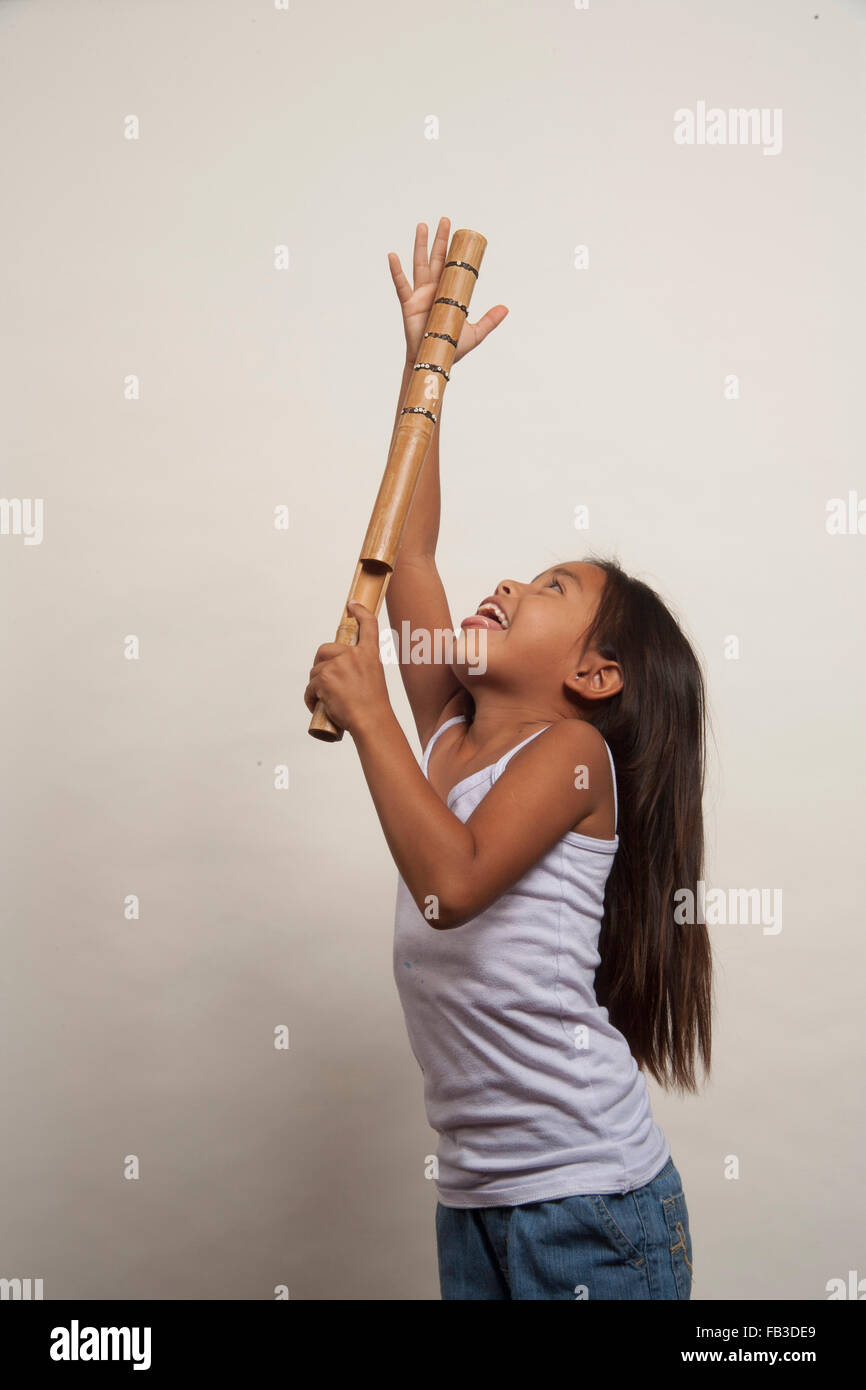 Un démonstratif Native American girl membre de la tribu Acjachemen démontre le battant bâton, un instrument de musique à percussion primitive. Communiqué de modèle Banque D'Images