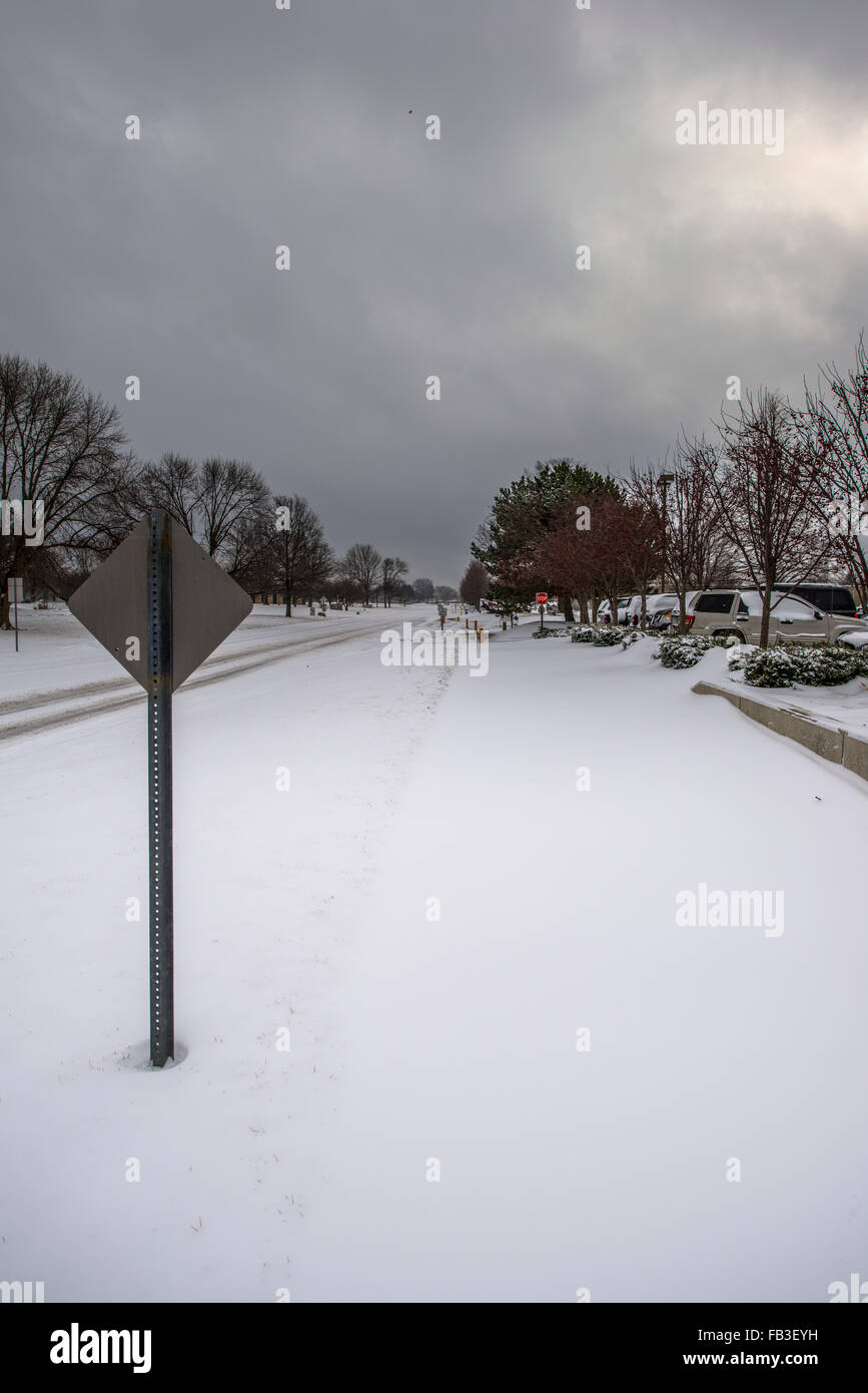 Une vue vers le bas une route couverte de neige gris comme les nuages de tempête soufflent dans Banque D'Images