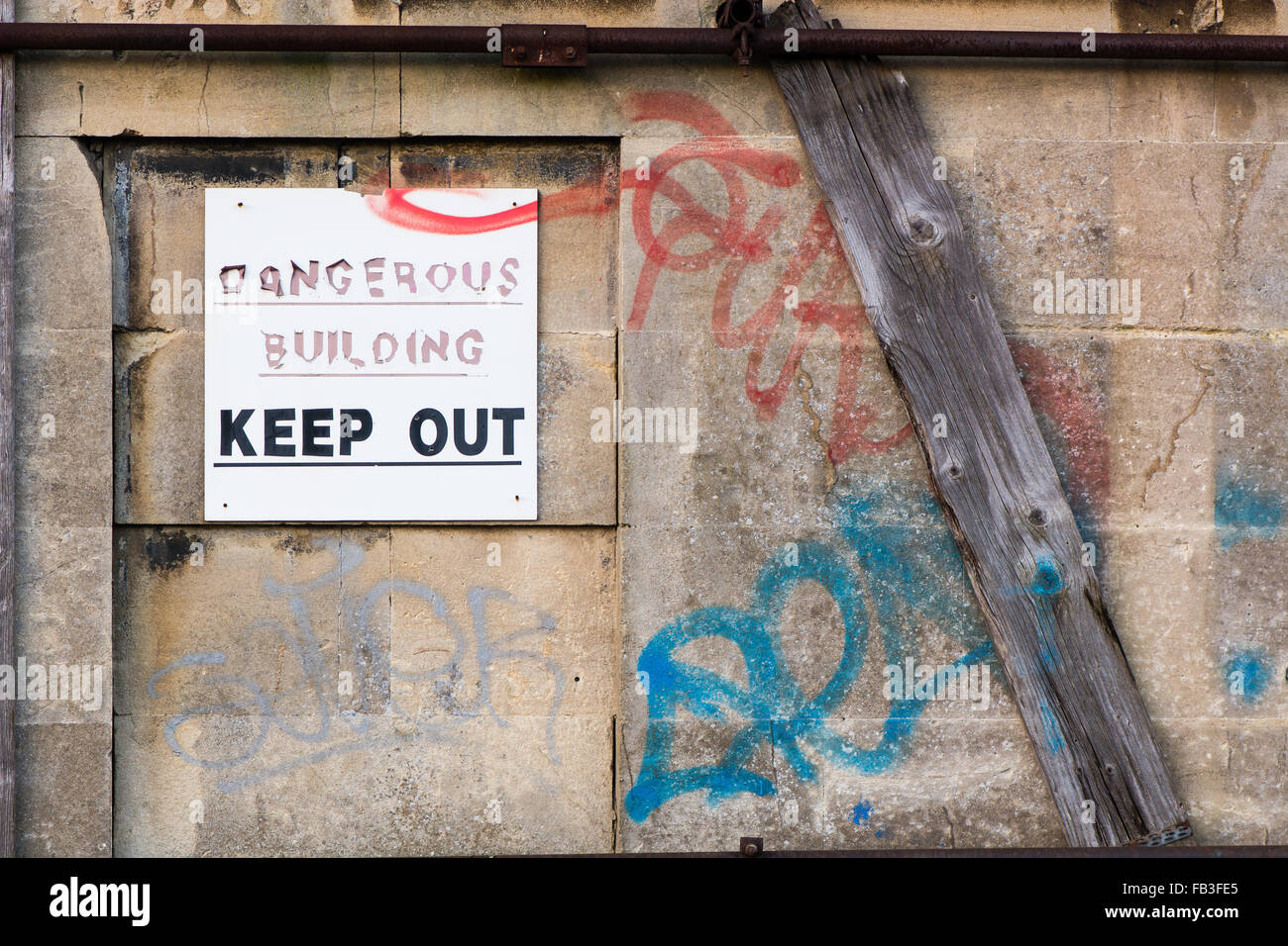 Bâtiment dangereux Tenir hors signe. Un peeling panneau d'avertissement sur des maisons abandonnées, offrant un avertissement pour les gens Banque D'Images