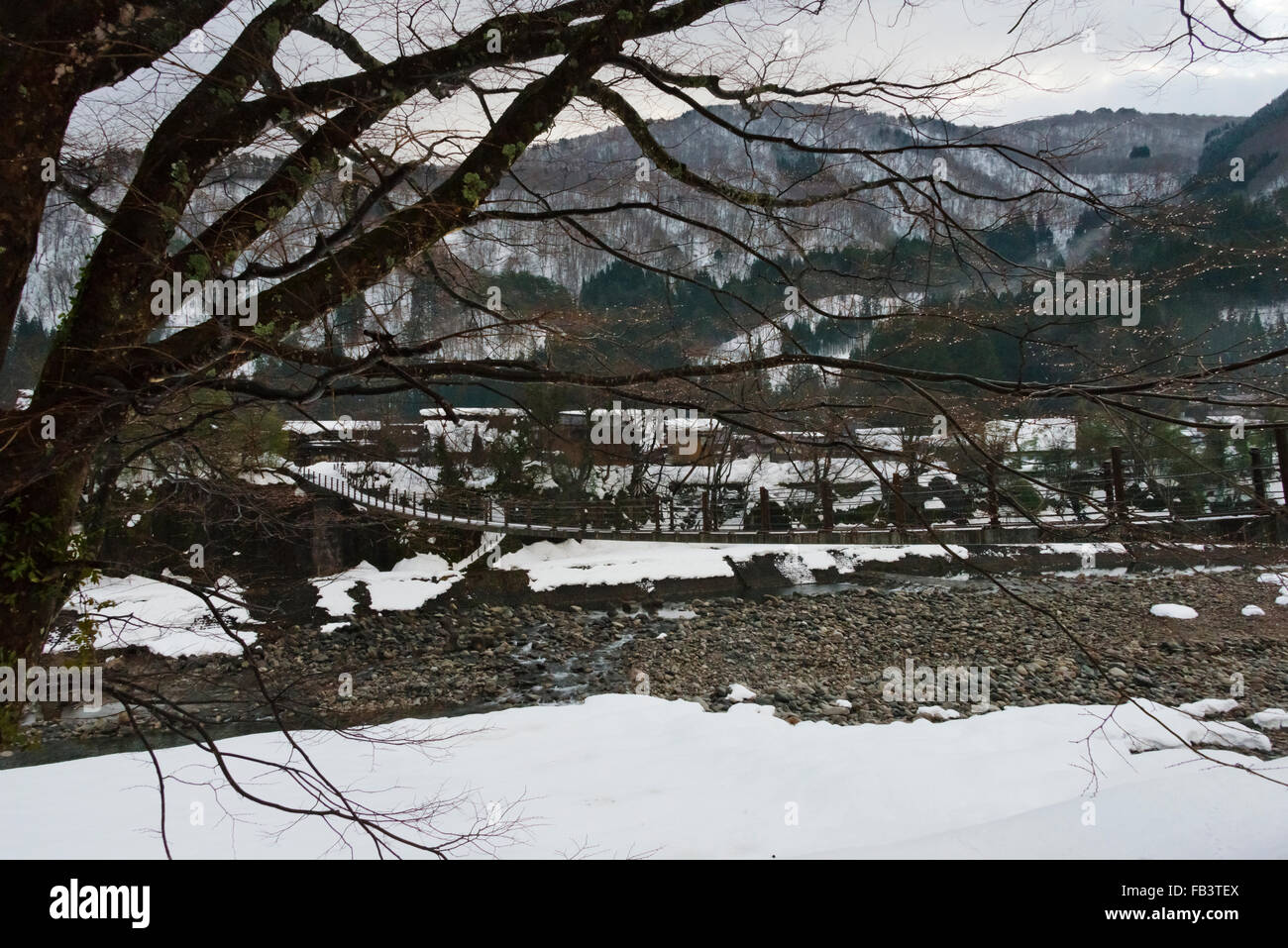 Pont et village couvert de neige dans la montagne, Shirakawa-go, préfecture de Gifu, Japon Banque D'Images