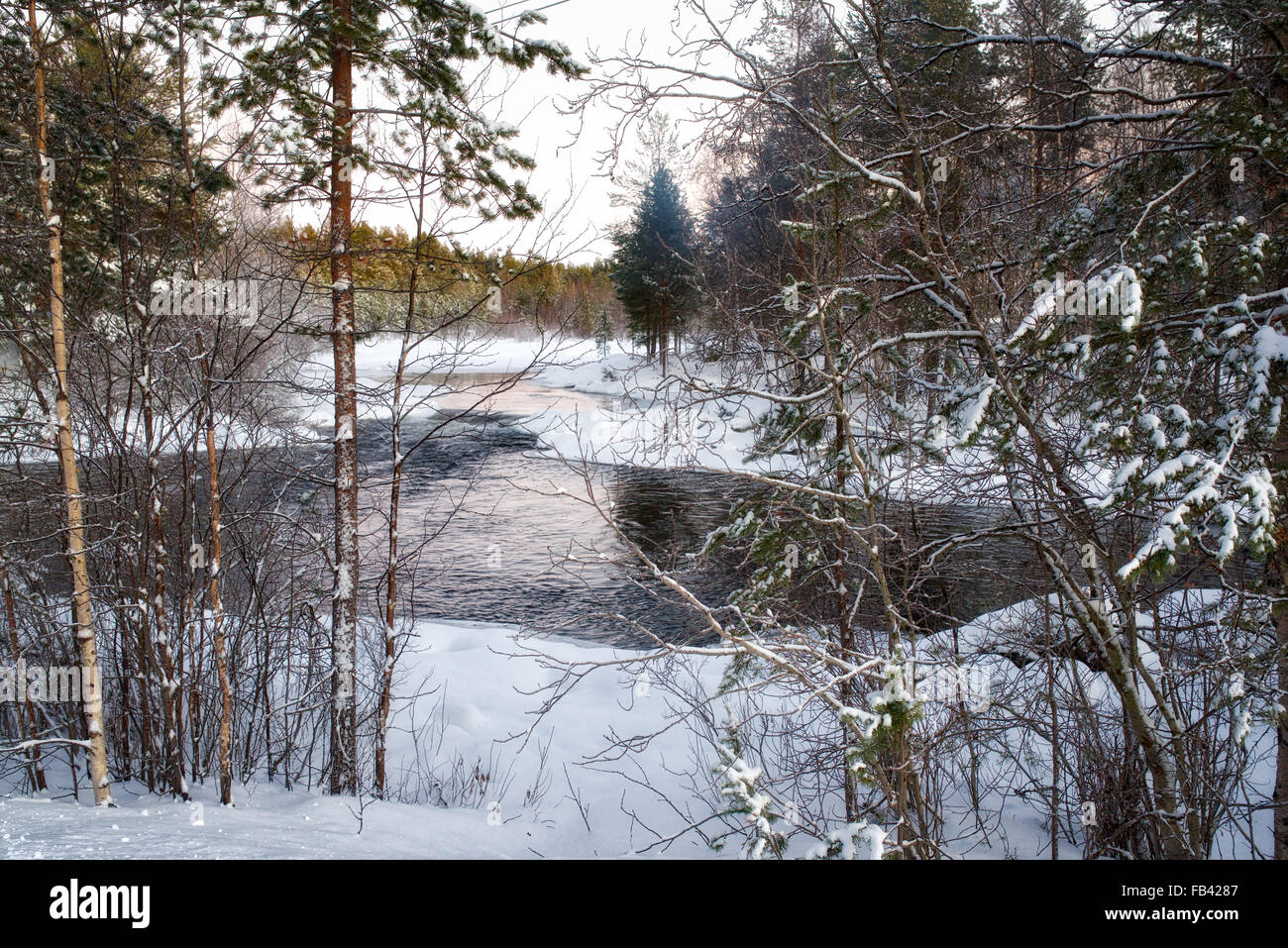 La rivière qui coule dans le paysage gelé, Finlande Banque D'Images