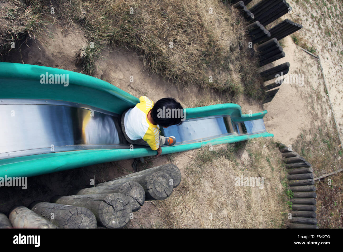 C'est une photo d'un enfant qui est glissant sur une diapositive dans une aire de jeux pour enfants Piscine en plein air. Banque D'Images