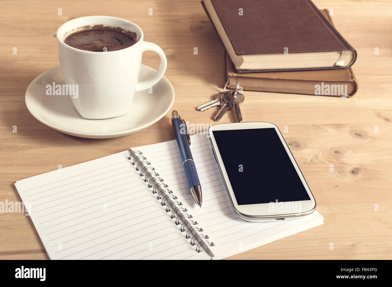 Still Life photo de smart phone, ordinateur portable, bouilloire, livre, un crayon et des clés sur la table en bois. Focus sélectif. Banque D'Images
