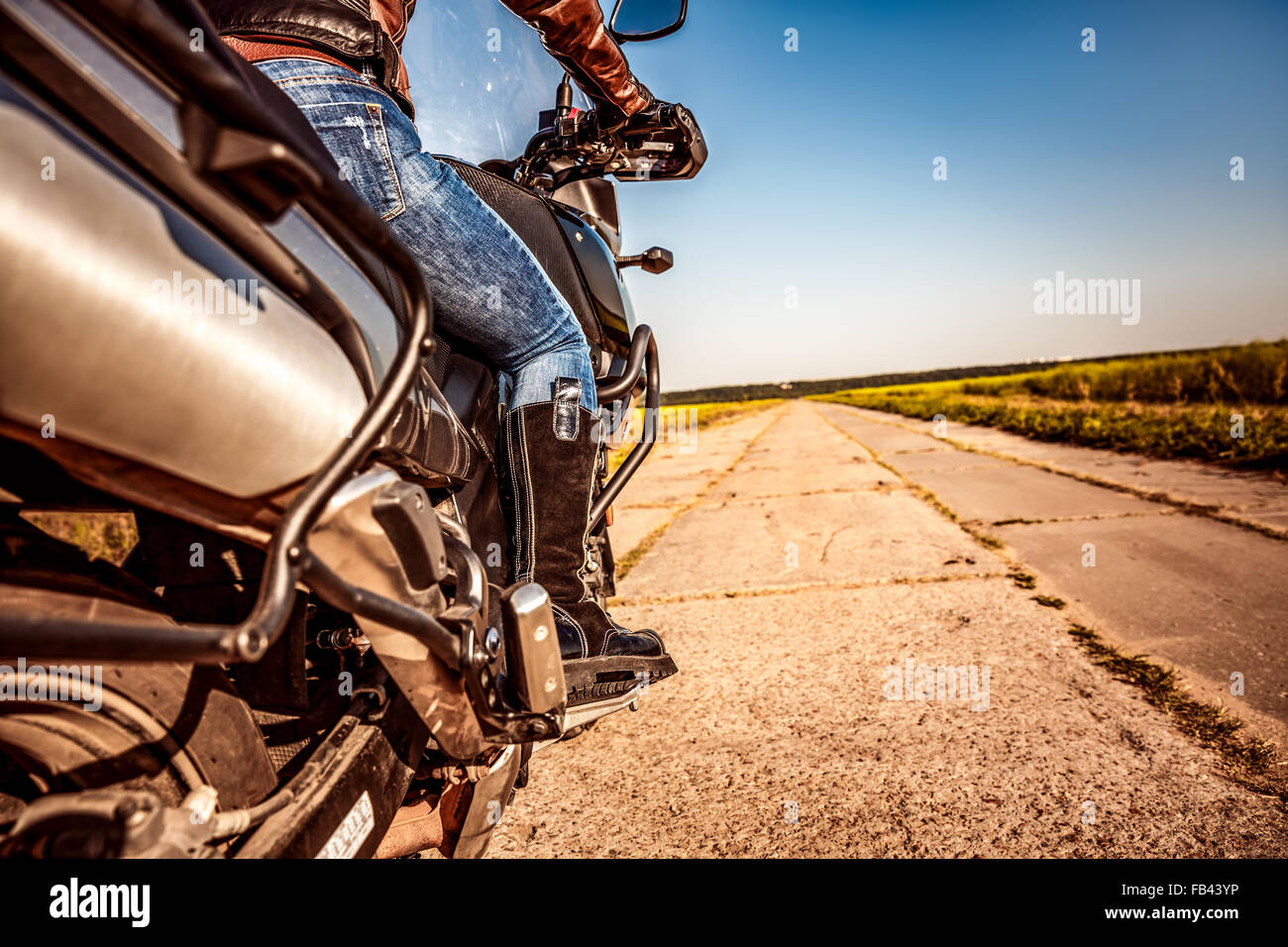 Biker girl riding sur une moto. Vue du bas des jambes dans des bottes de cuir. Banque D'Images