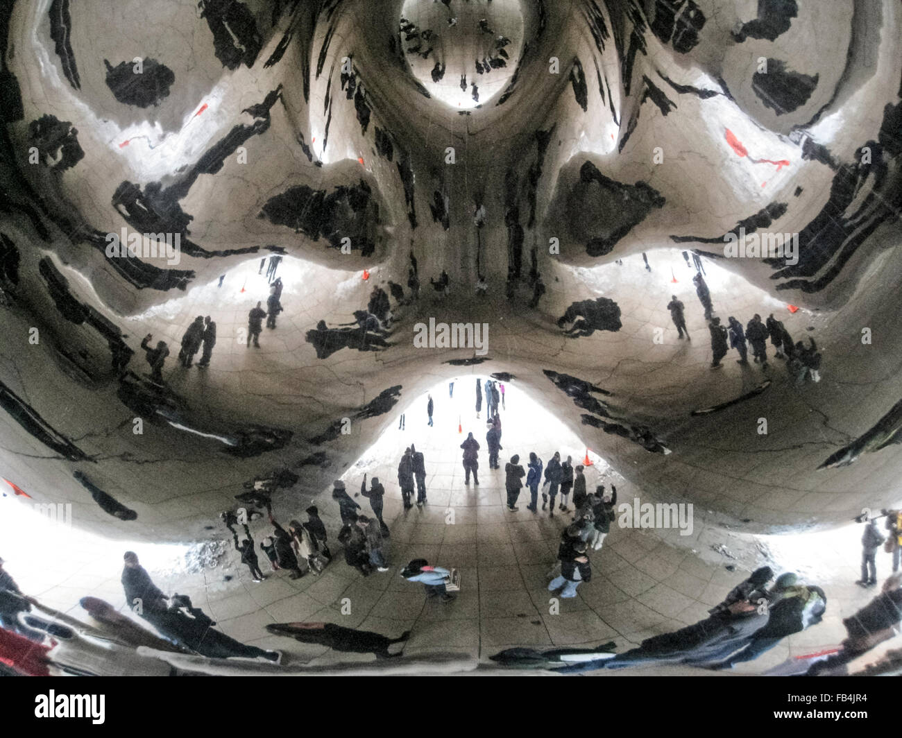 Reflets déformés sont vus d'excursionnistes à sous à 'l'haricot, le surnom populaire' pour 'Cloud Gate, un des 110 tonnes sculpture elliptique dans le Millennium Park de Chicago, Illinois, USA. L'artiste britannique Anish Kapoor a créé le monument brillant avec des morceaux d'acier inoxydable qui ont été soudés ensemble et puis polies pour éliminer tous les joints. L'œuvre a pris deux ans et a été dévoilé en 2006. Il est devenu depuis l'une des principales attractions touristiques de la ville des vents. Banque D'Images