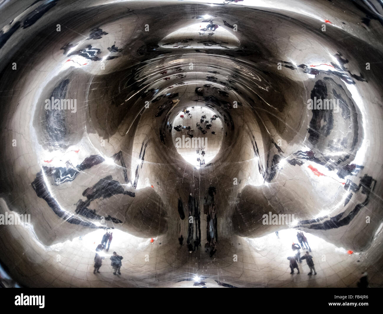 Reflets déformés sont vus d'excursionnistes à sous à 'l'haricot, le surnom populaire' pour 'Cloud Gate, un des 110 tonnes sculpture elliptique dans le Millennium Park de Chicago, Illinois, USA. L'artiste britannique Anish Kapoor a créé le monument brillant avec des morceaux d'acier inoxydable qui ont été soudés ensemble et puis polies pour éliminer tous les joints. L'œuvre a pris deux ans et a été dévoilé en 2006. Il est devenu depuis l'une des principales attractions touristiques de la ville des vents. Banque D'Images