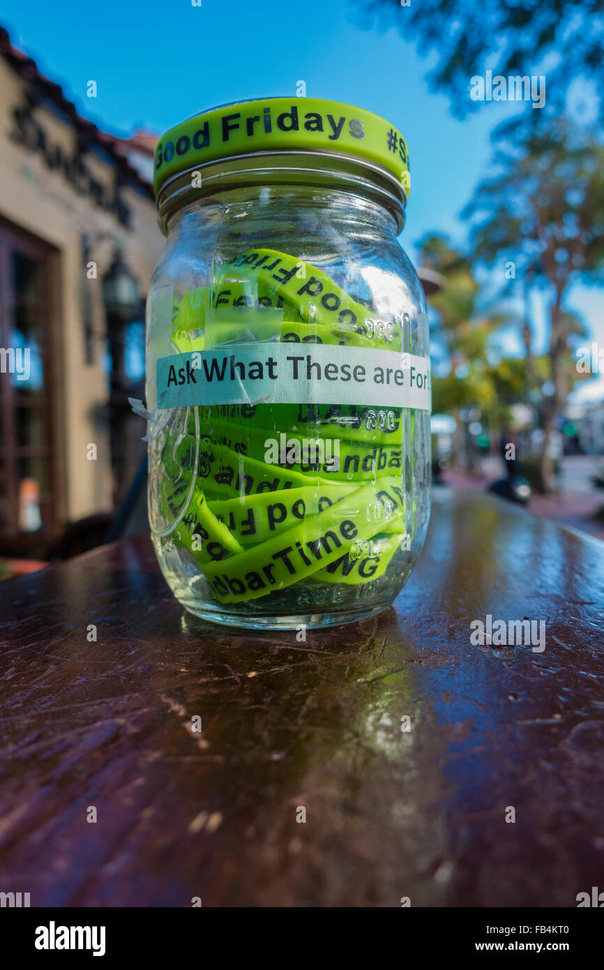 Un gros plan d'un pot plein de bracelets verts pour le Vendredi saint dans un bar de Santa Barbara, en Californie. Les bracelets sont en vente Banque D'Images