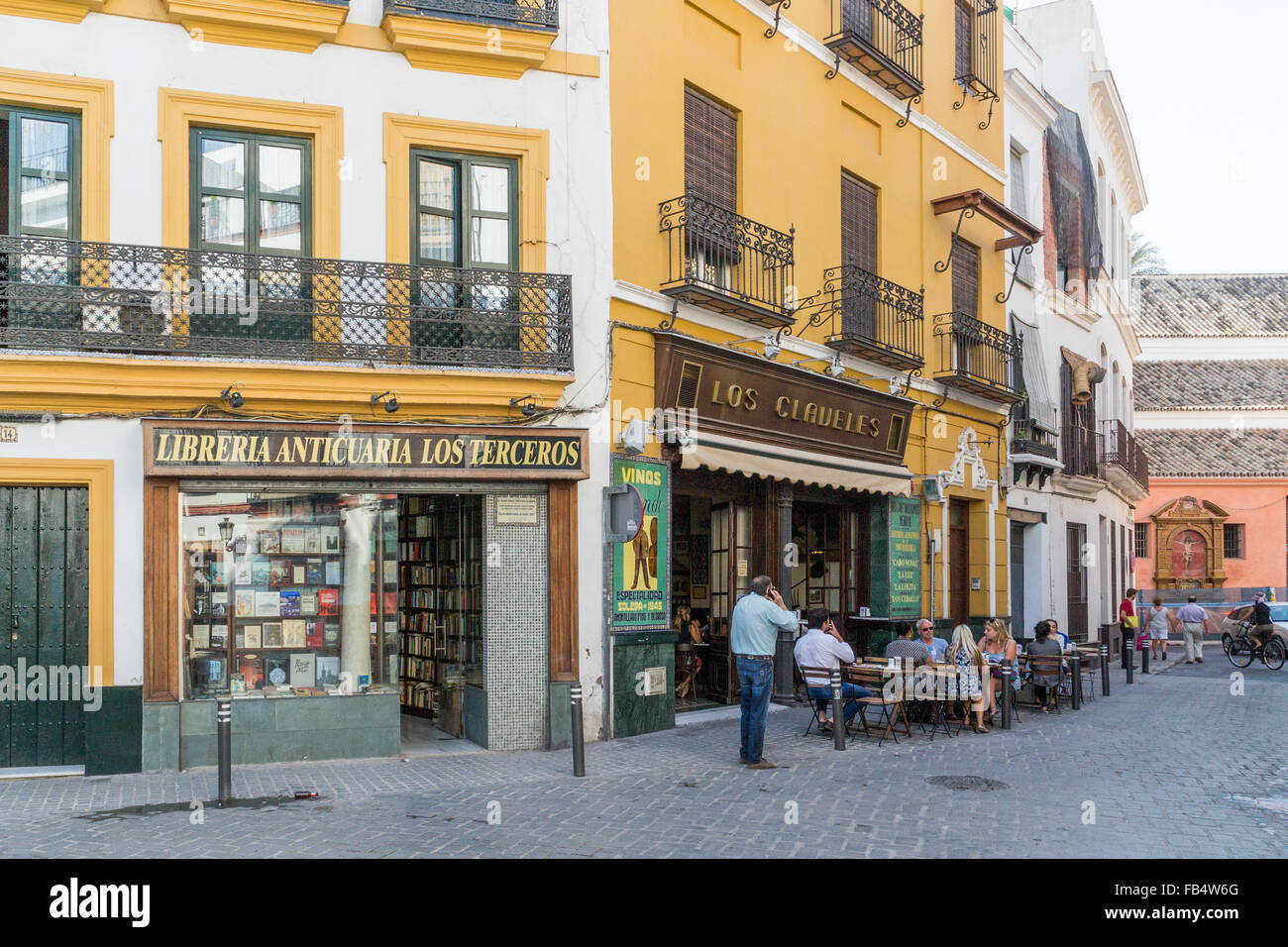 Scène de rue - les gens de boire du café à l'extérieur d'un café et de l'homme sur téléphone mobile à Séville, Andalousie, Espagne Banque D'Images