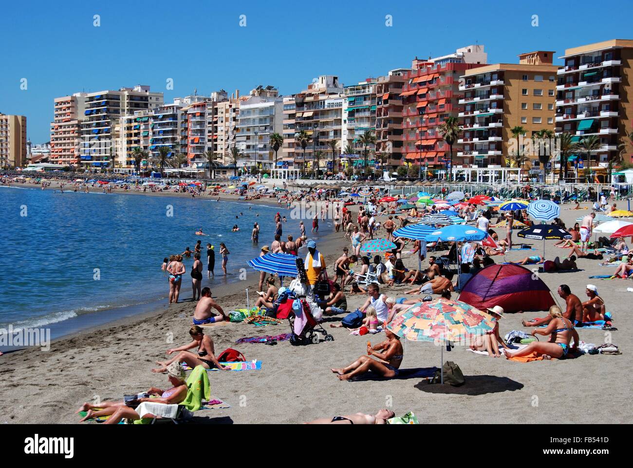 Les vacanciers se détendre sur la plage avec hôtels et appartements à l'arrière, Fuengirola, province de Malaga, Andalousie, espagne. Banque D'Images