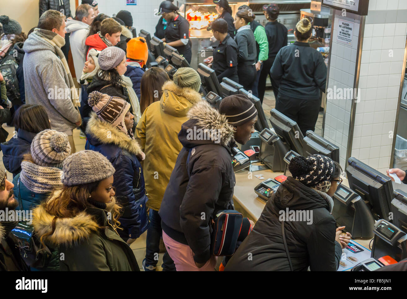 Les clients désireux de la faim et de la foule du compteur à un restaurant McDonald à Times Square à New York le mardi, Janvier 5, 2016. McDonald's du troisième trimestre, les ventes ont progressé de 0,9  %, leur première hausse en deux ans. McDonald's, Wendy's et Burger King ont tous lancé valeur limitée des choix de repas et petit-déjeuner toute la journée du McD a aidé à stimuler son dernier trimestre. (© Richard B. Levine) Banque D'Images