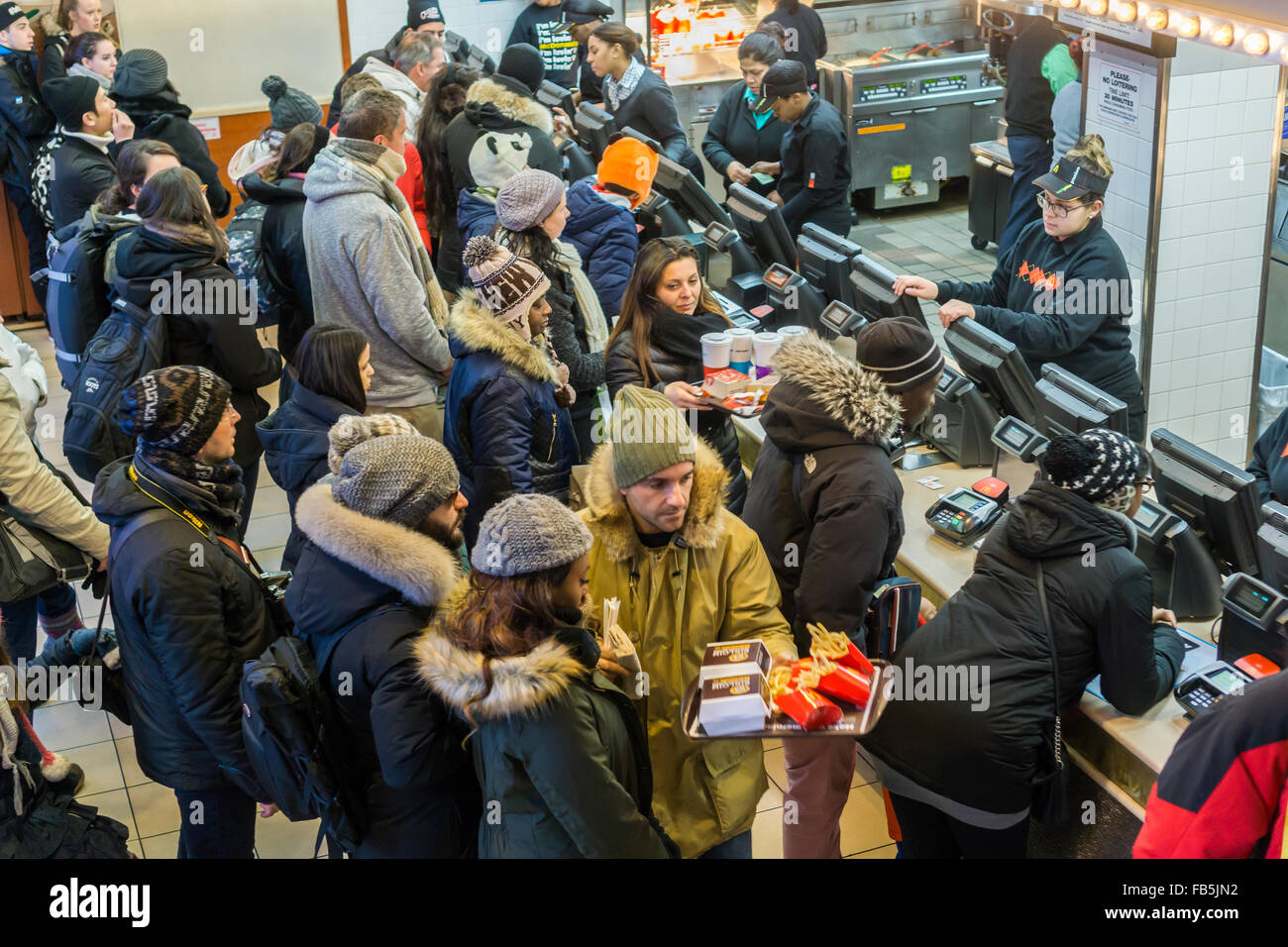 Les clients désireux de la faim et de la foule du compteur à un restaurant McDonald à Times Square à New York le mardi, Janvier 5, 2016. McDonald's du troisième trimestre, les ventes ont progressé de 0,9  %, leur première hausse en deux ans. McDonald's, Wendy's et Burger King ont tous lancé valeur limitée des choix de repas et petit-déjeuner toute la journée du McD a aidé à stimuler son dernier trimestre. (© Richard B. Levine) Banque D'Images