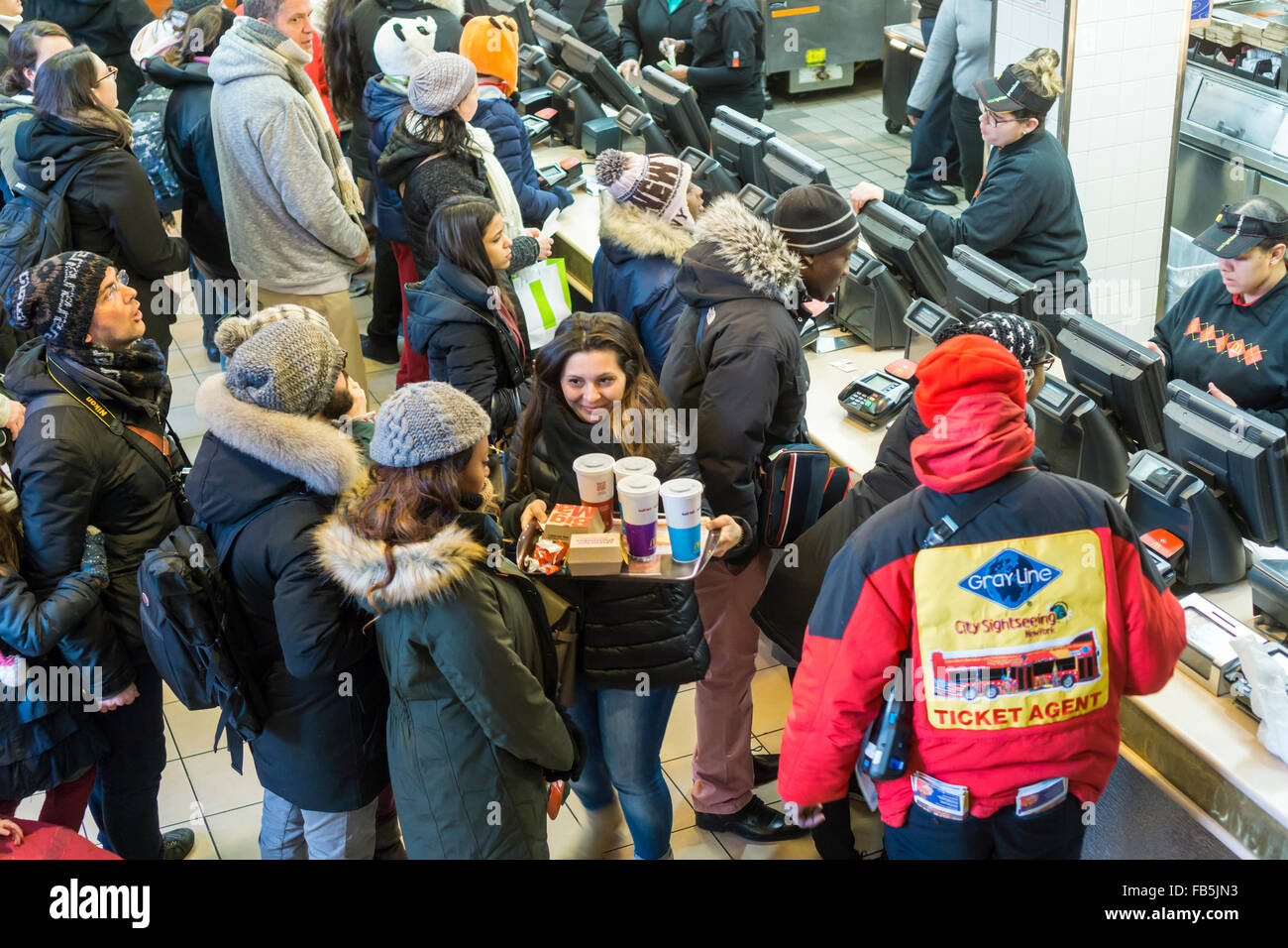 Les clients désireux de la faim et de la foule du compteur à un restaurant McDonald à Times Square à New York le mardi, Janvier 5, 2016. McDonald's du troisième trimestre, les ventes ont progressé de 0,9  %, leur première hausse en deux ans. McDonald's, Wendy's et Burger King ont tous lancé valeur limitée des choix de repas et petit-déjeuner toute la journée du McD a aidé à stimuler son dernier trimestre. (© Richard B. Levine) Banque D'Images