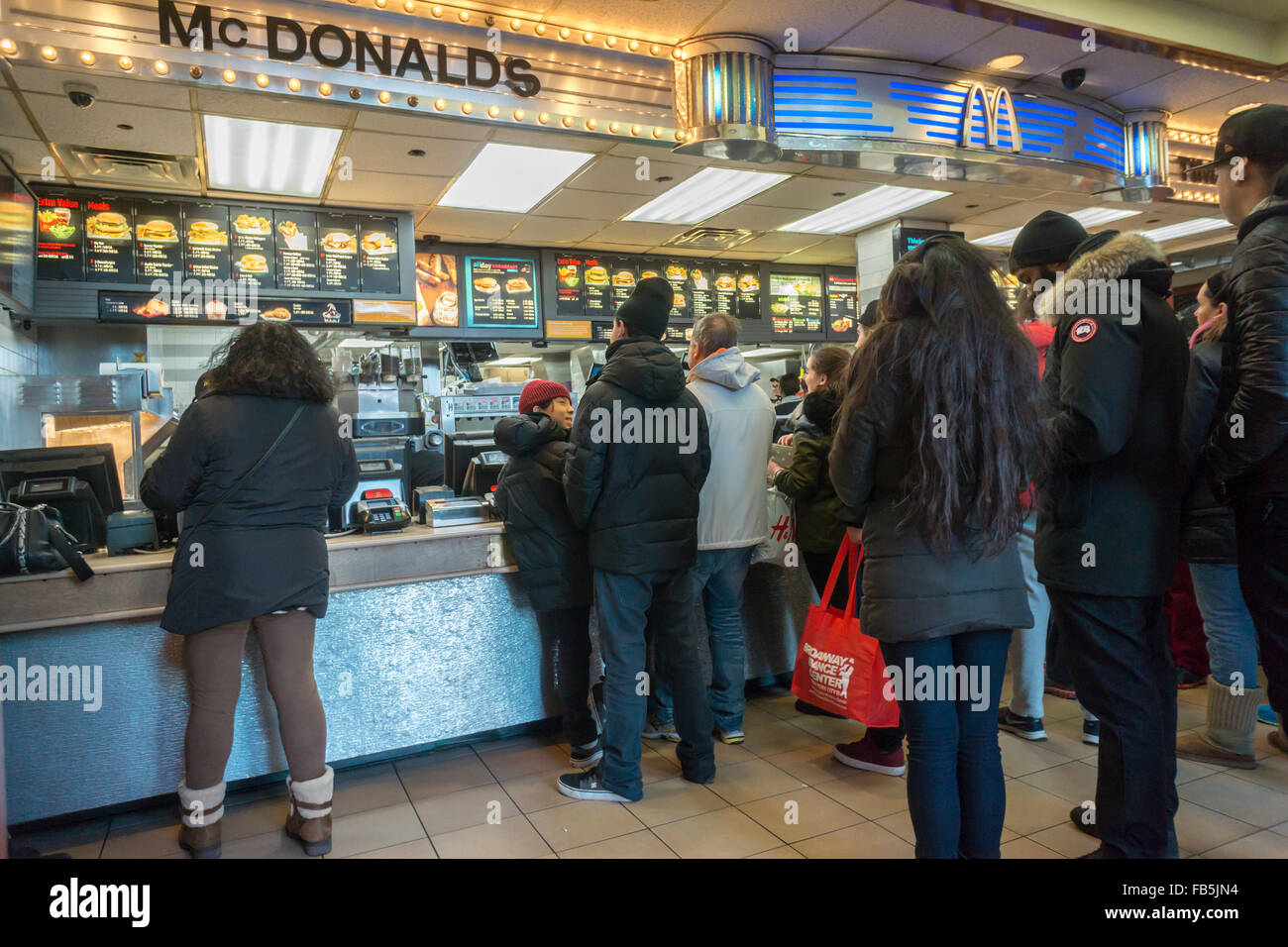 Les clients désireux de la faim et de la foule du compteur à un restaurant McDonald à Times Square à New York le mardi, Janvier 5, 2016. McDonald's du troisième trimestre, les ventes ont progressé de 0,9  %, leur première hausse en deux ans. McDonald's, Wendy's et Burger King ont tous lancé valeur limitée des choix de repas et petit-déjeuner toute la journée du McD a aidé à stimuler son dernier trimestre. (© Richard B. Levine) Banque D'Images