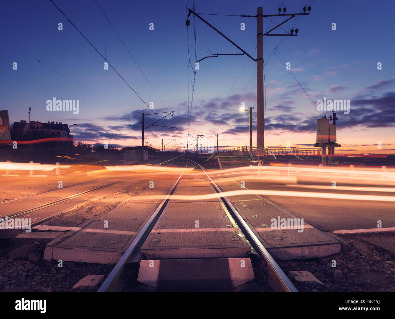 Railroad crossing avec ampoule de voiture en mouvement dans la nuit. Banque D'Images