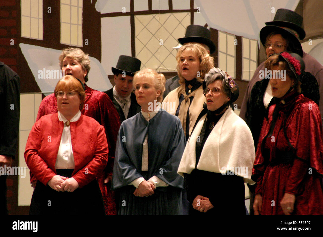 Une chorale à l'église habillés de costumes de Noël 1800 Signature à un jeu de Noël. Banque D'Images
