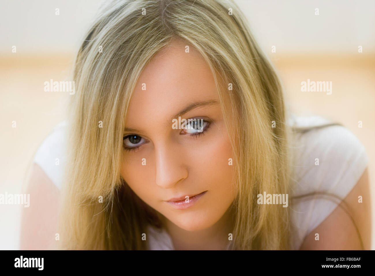 Et la tête de l'épaule, 18 ans, femme face avec eye-contact. De longs cheveux blonds, les yeux bleus. L'expression grave. Soft focus. Banque D'Images