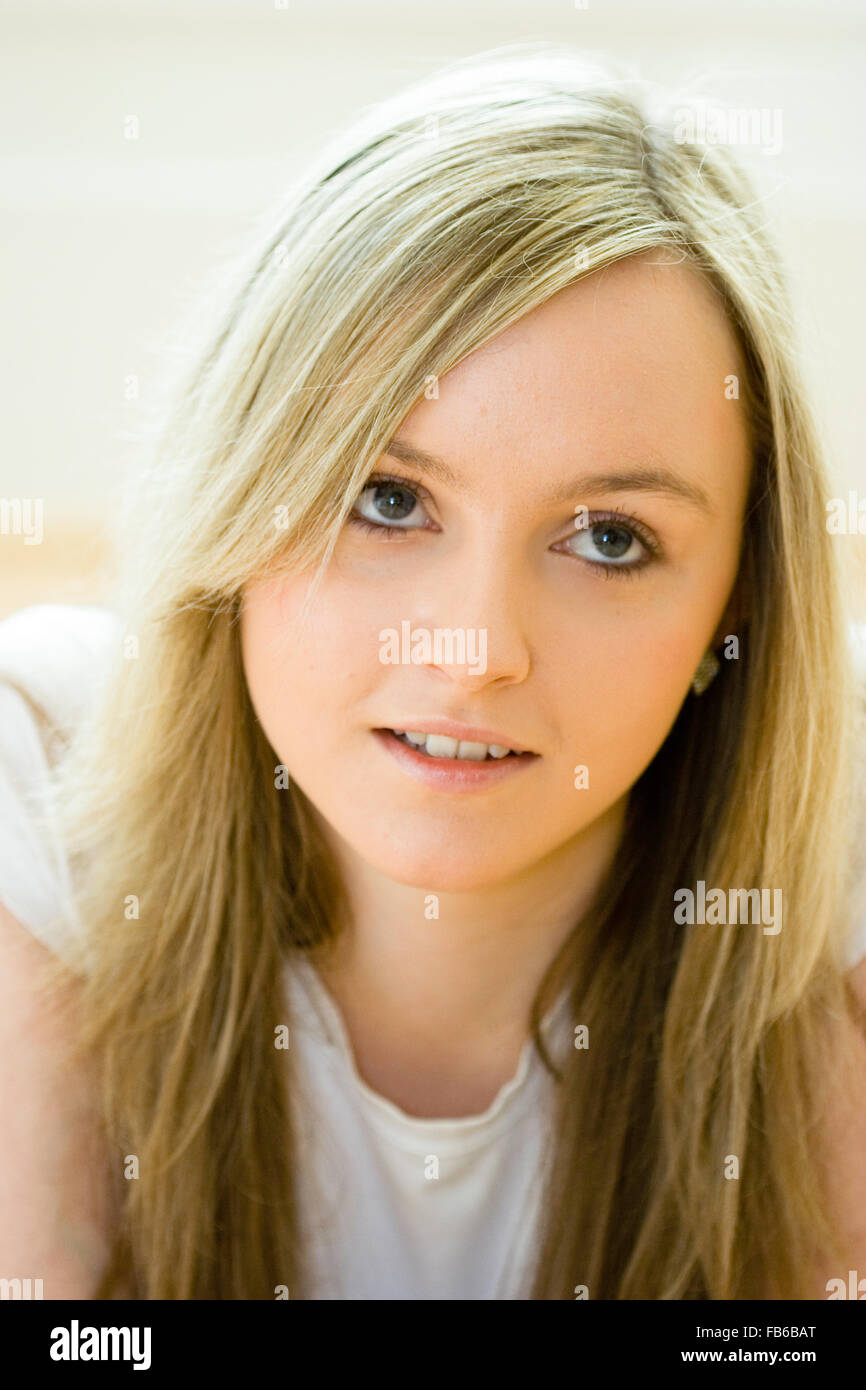 Et la tête de l'épaule, 18 ans, femme, les yeux face à la recherche. De longs cheveux blonds, les yeux bleus. En souriant. Soft focus. Banque D'Images