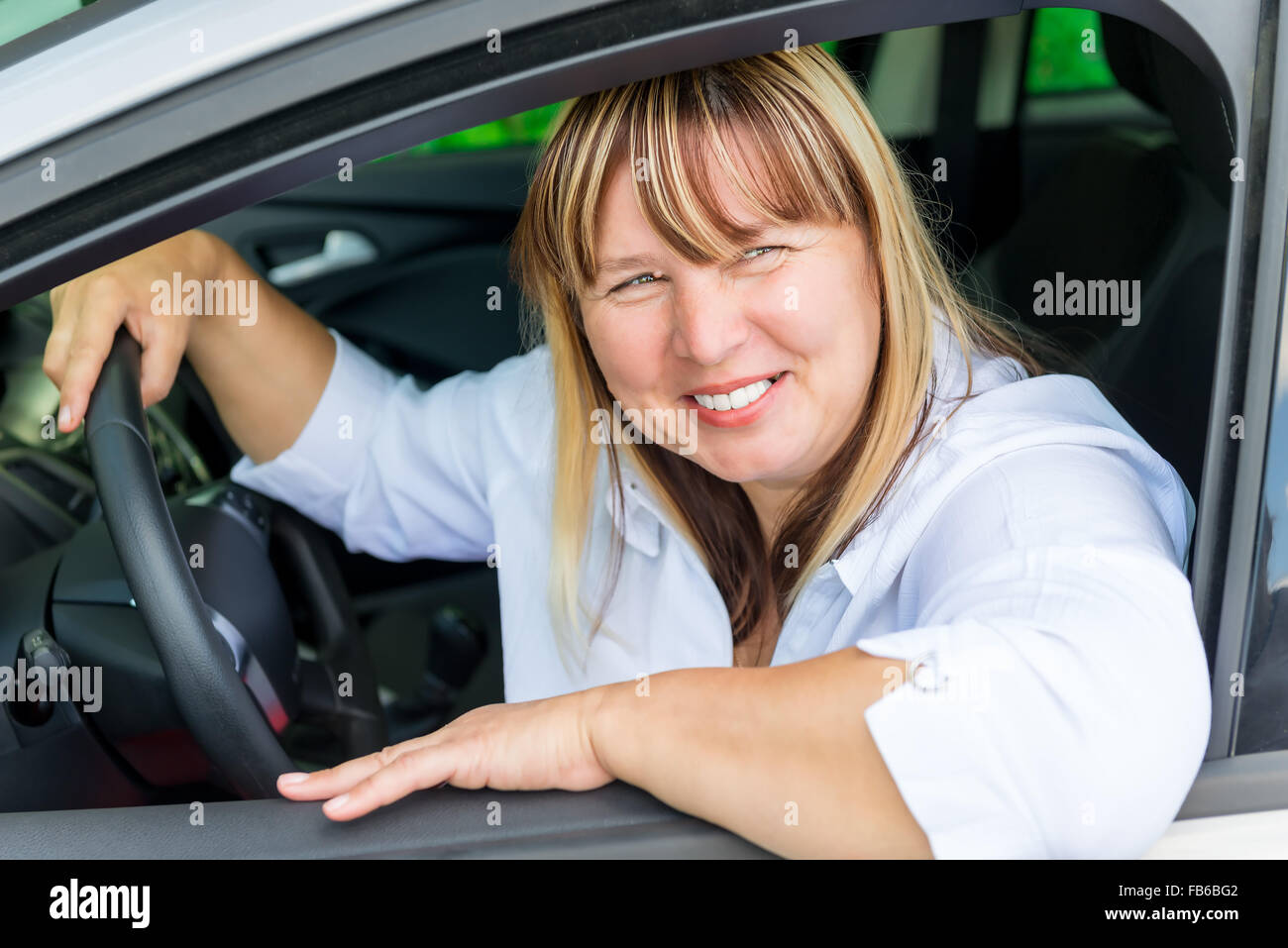 La pilote de 50 ans heureux dans la voiture Banque D'Images