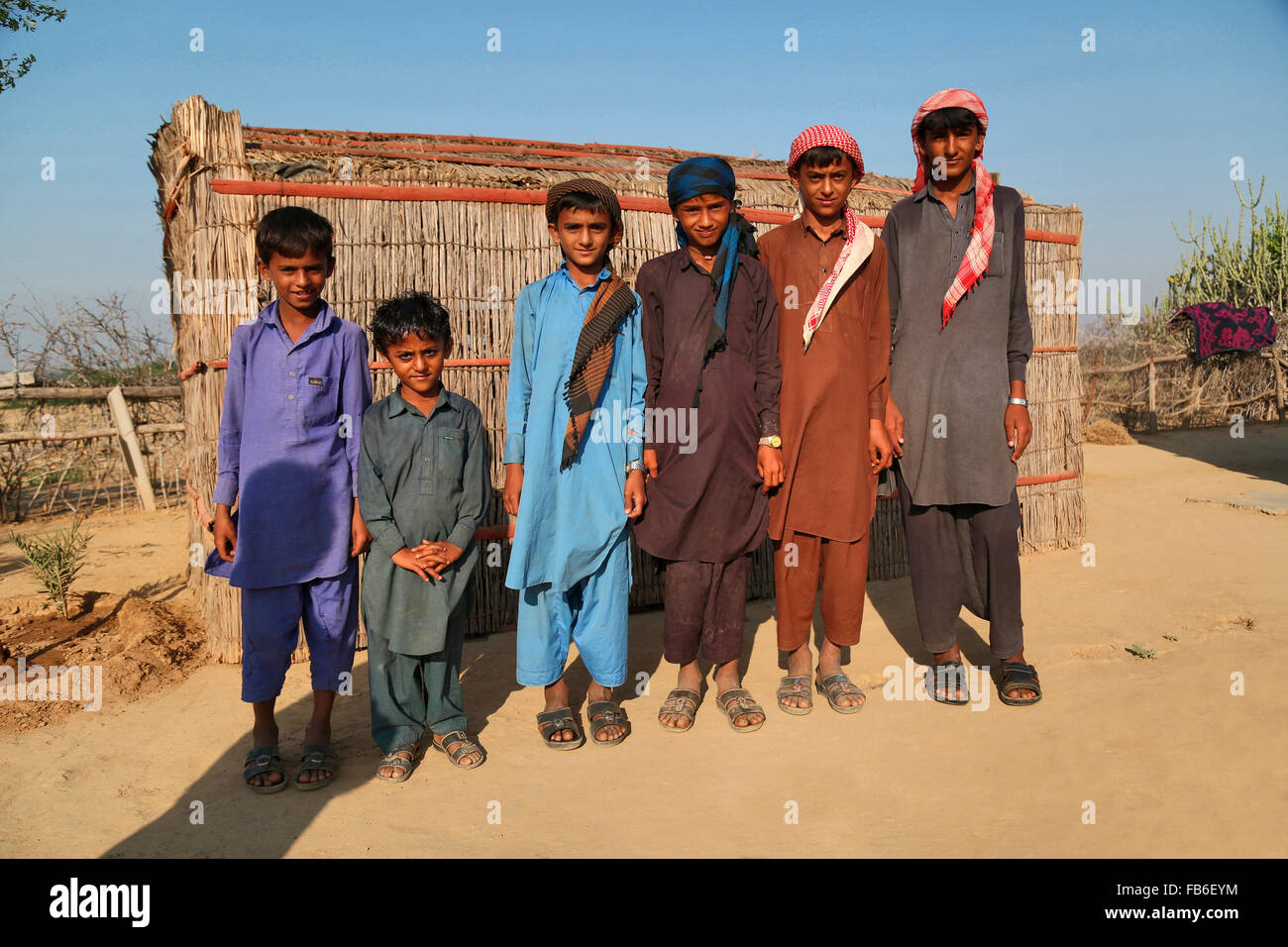 Fakirani tribu Jat, les enfants en costume traditionnel standing in front of house appelé Havamahal, district de Kutch, Gujarat, Inde Banque D'Images