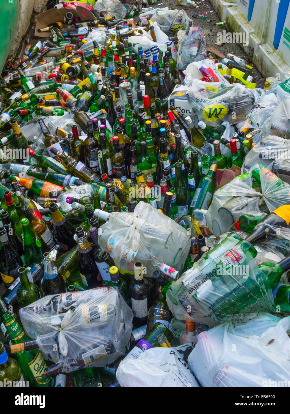 Les bacs de recyclage pour le verre mélangé trop remplis et avec des bouteilles entassées à côté après les célébrations du Nouvel An Banque D'Images