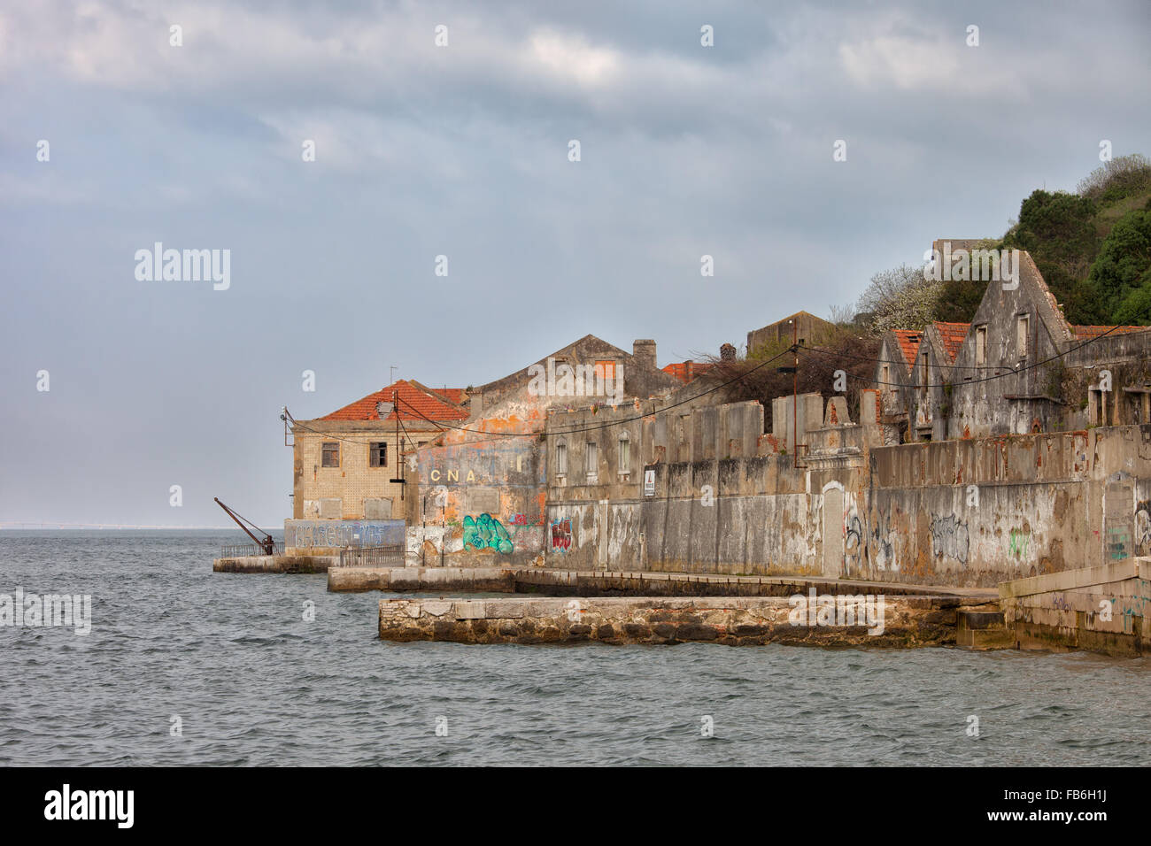Vieux quai avec abandonnée, de bâtiments par le Tage à Almada, Portugal Banque D'Images