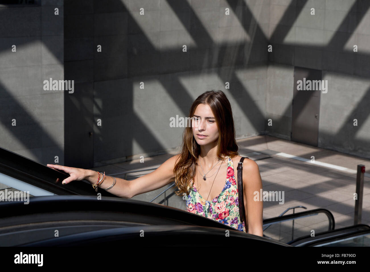 Young woman on escalator Banque D'Images