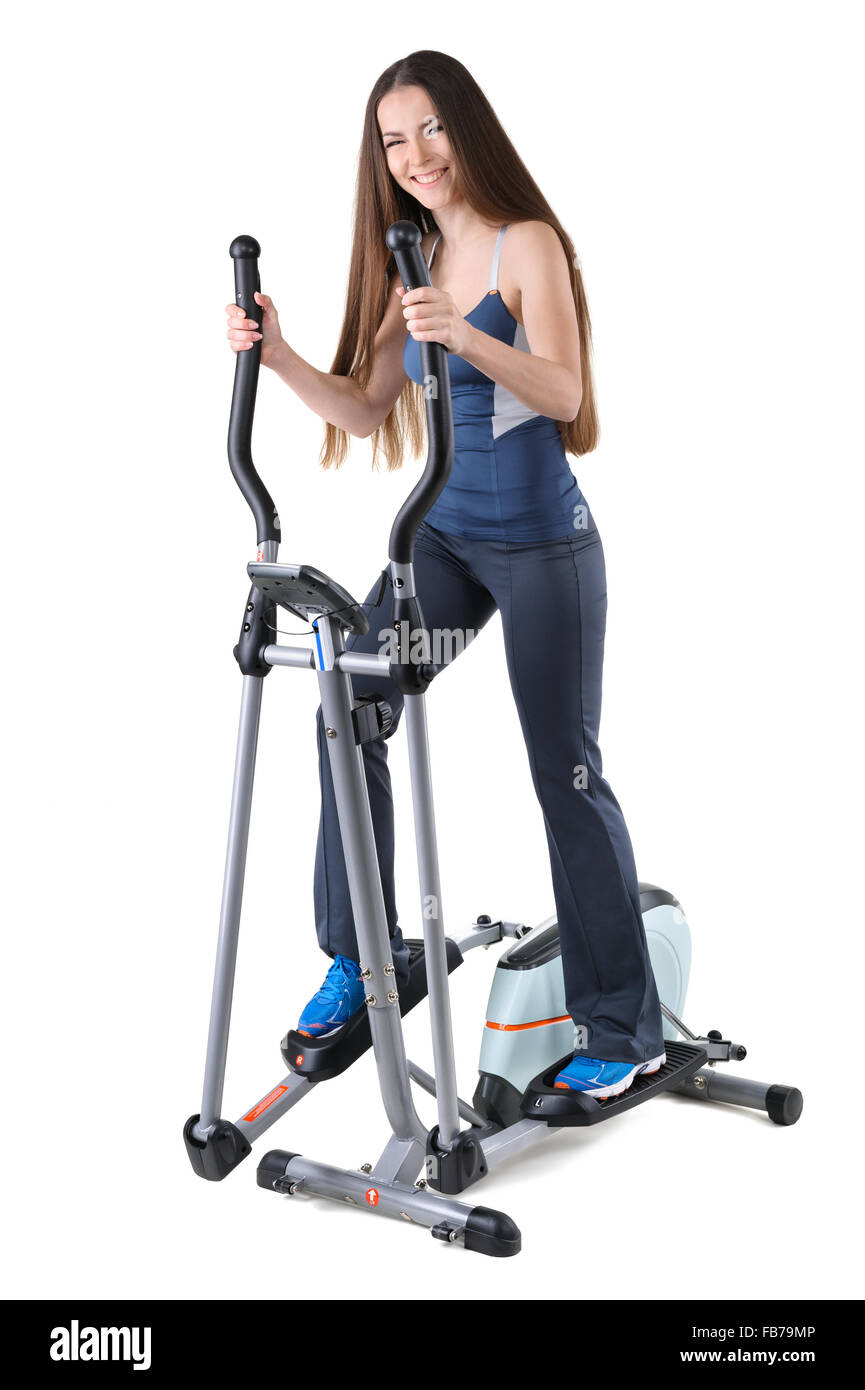 Jeune femme faisant des exercices sur l'entraîneur elliptique Banque D'Images